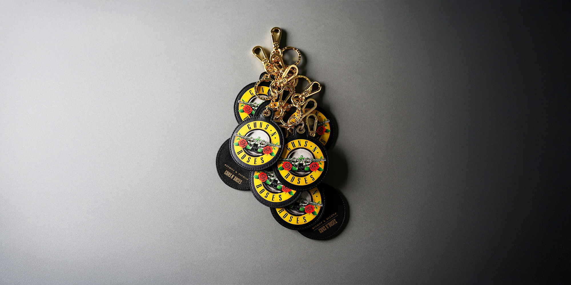 Collection of 'Guns N' Roses' branded keychains on a gray background