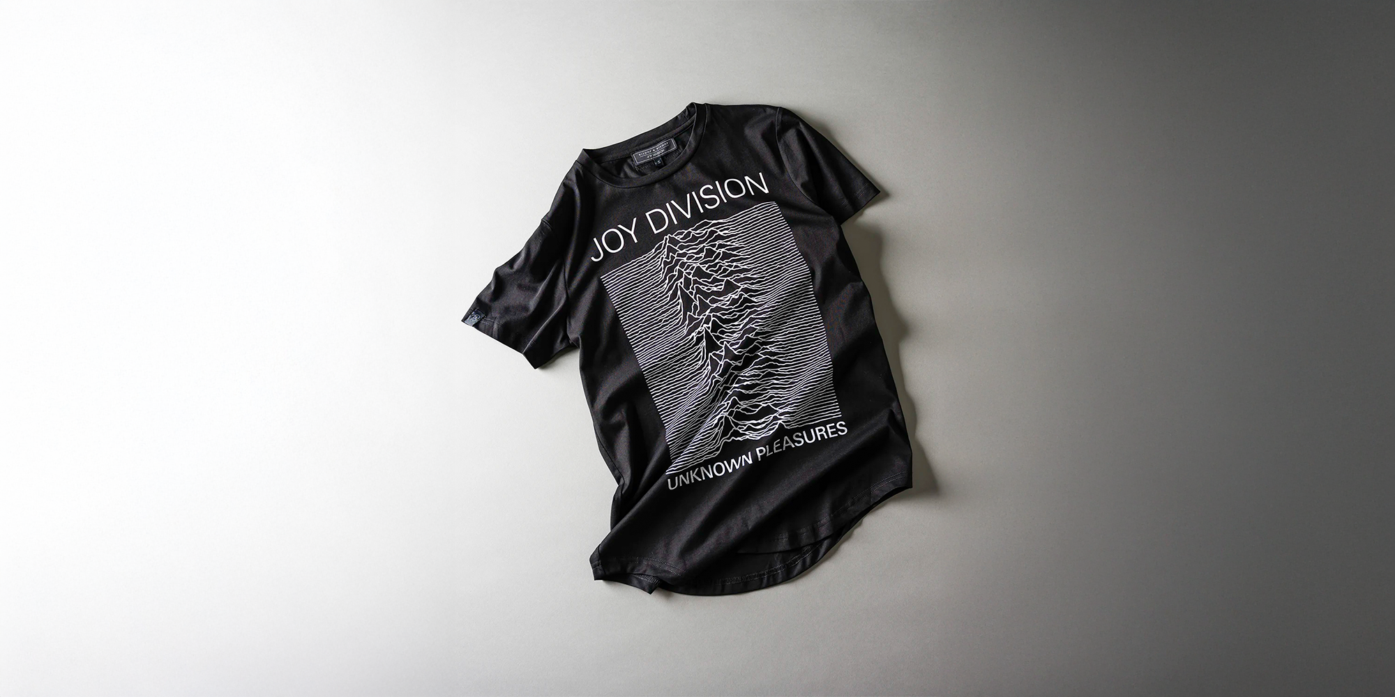 Black t-shirt with graphic design and text on a light gray background