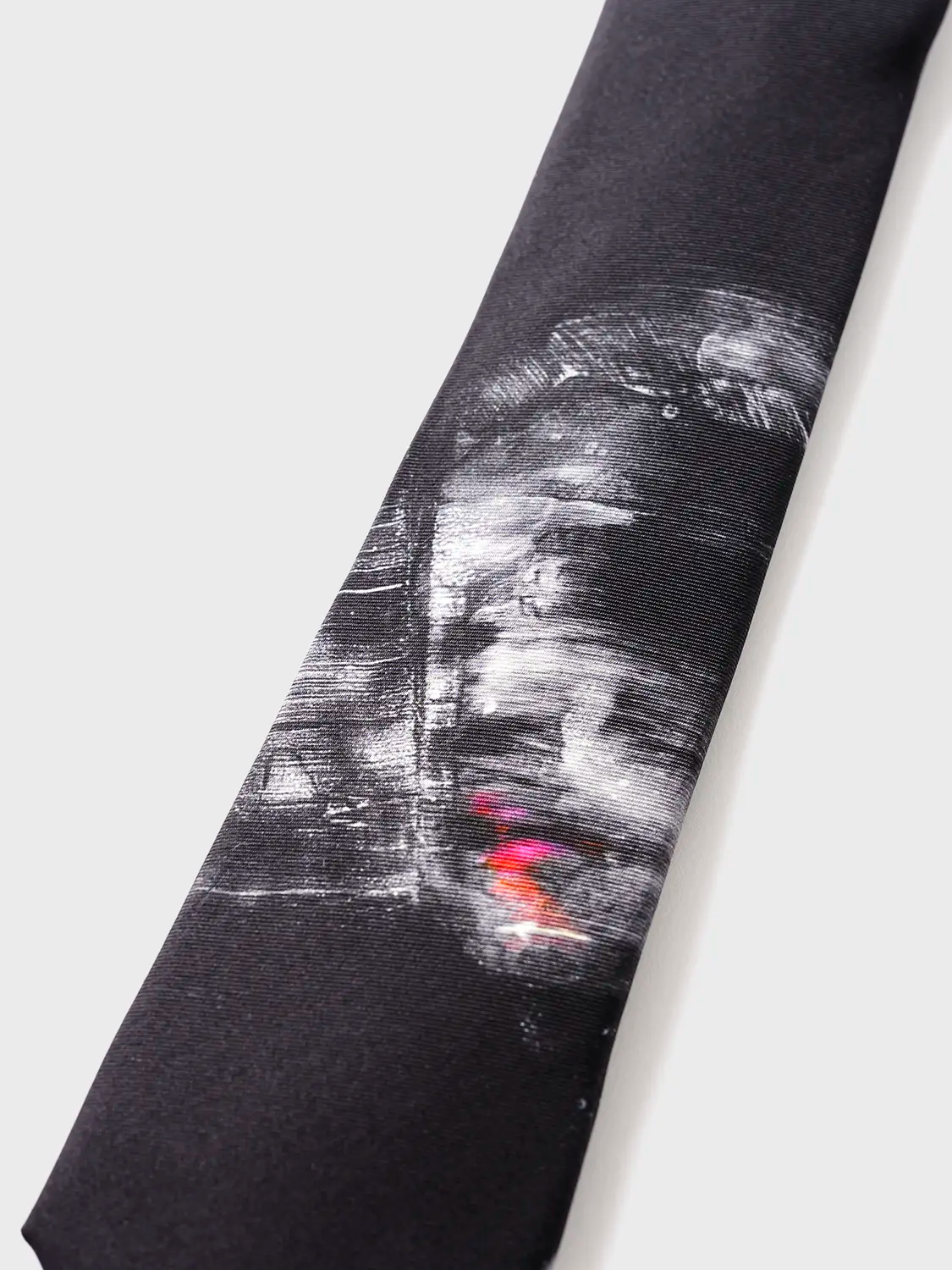 Black tie with abstract white and red design on a white background