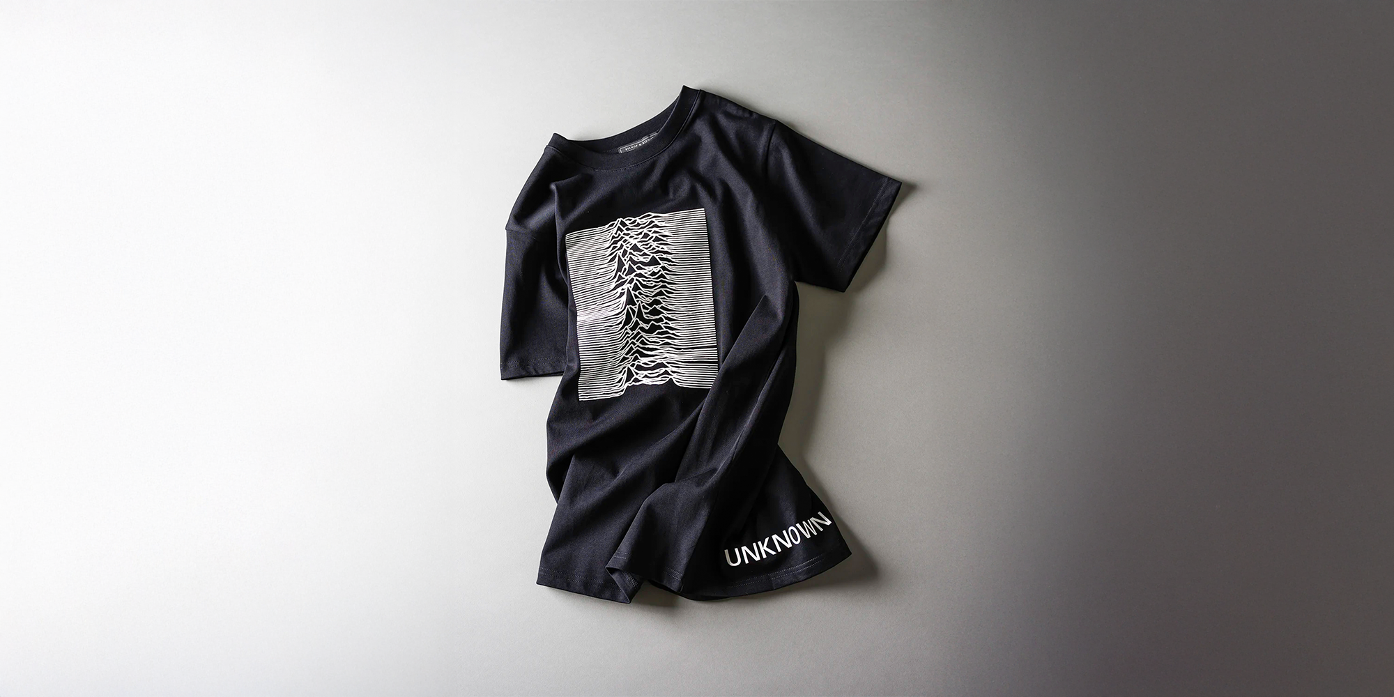 Black t-shirt with graphic design on a light gray background