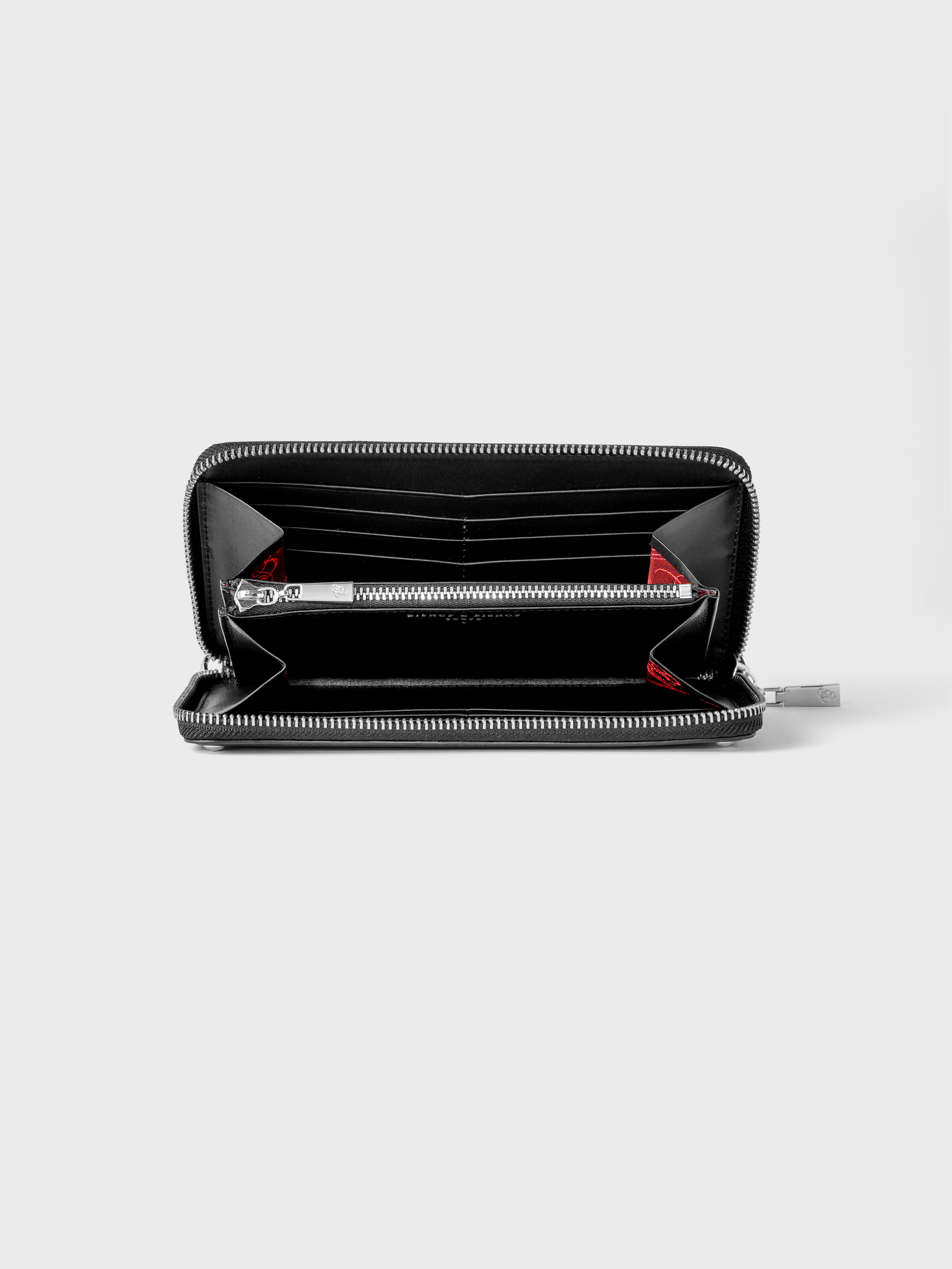 Open black wallet with a silver zipper, revealing red interior details.