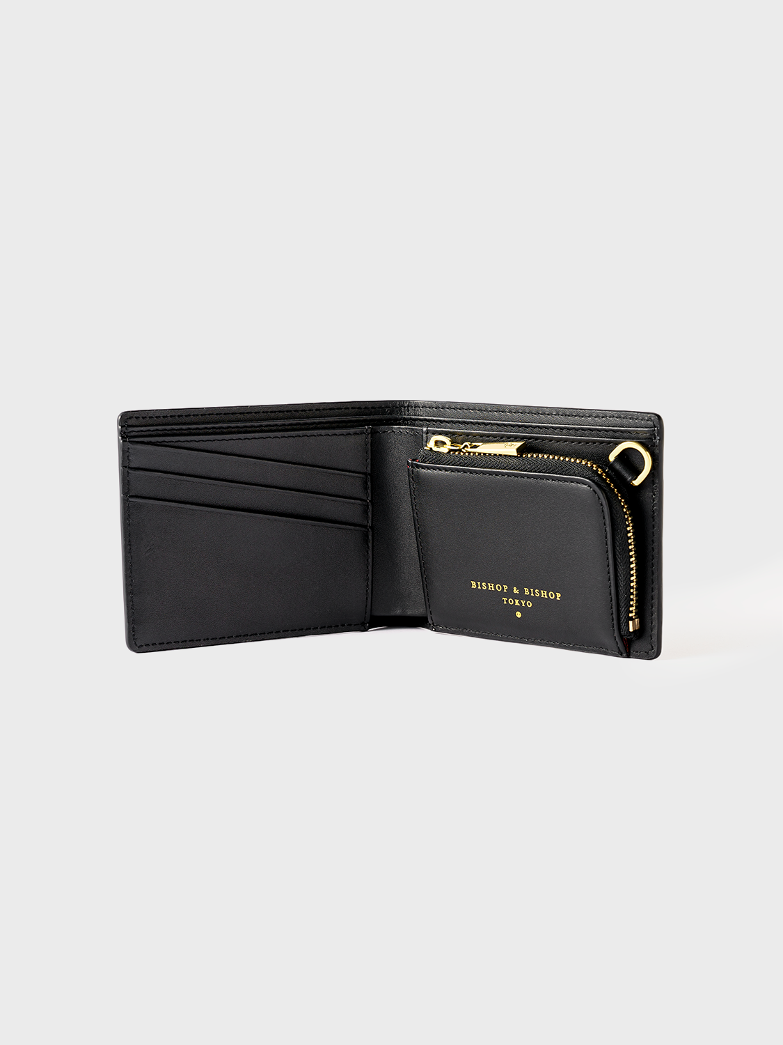 Black wallet with a gold zipper, shown open on a gray background.