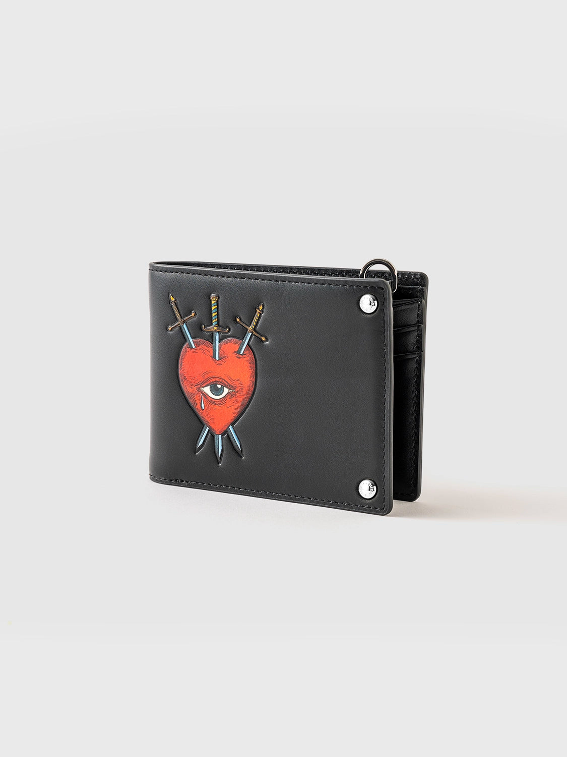 A black billfold wallet with a red heart, an eye, and crossed swords and silver-toned zinc alloy hardware featuring a key design.