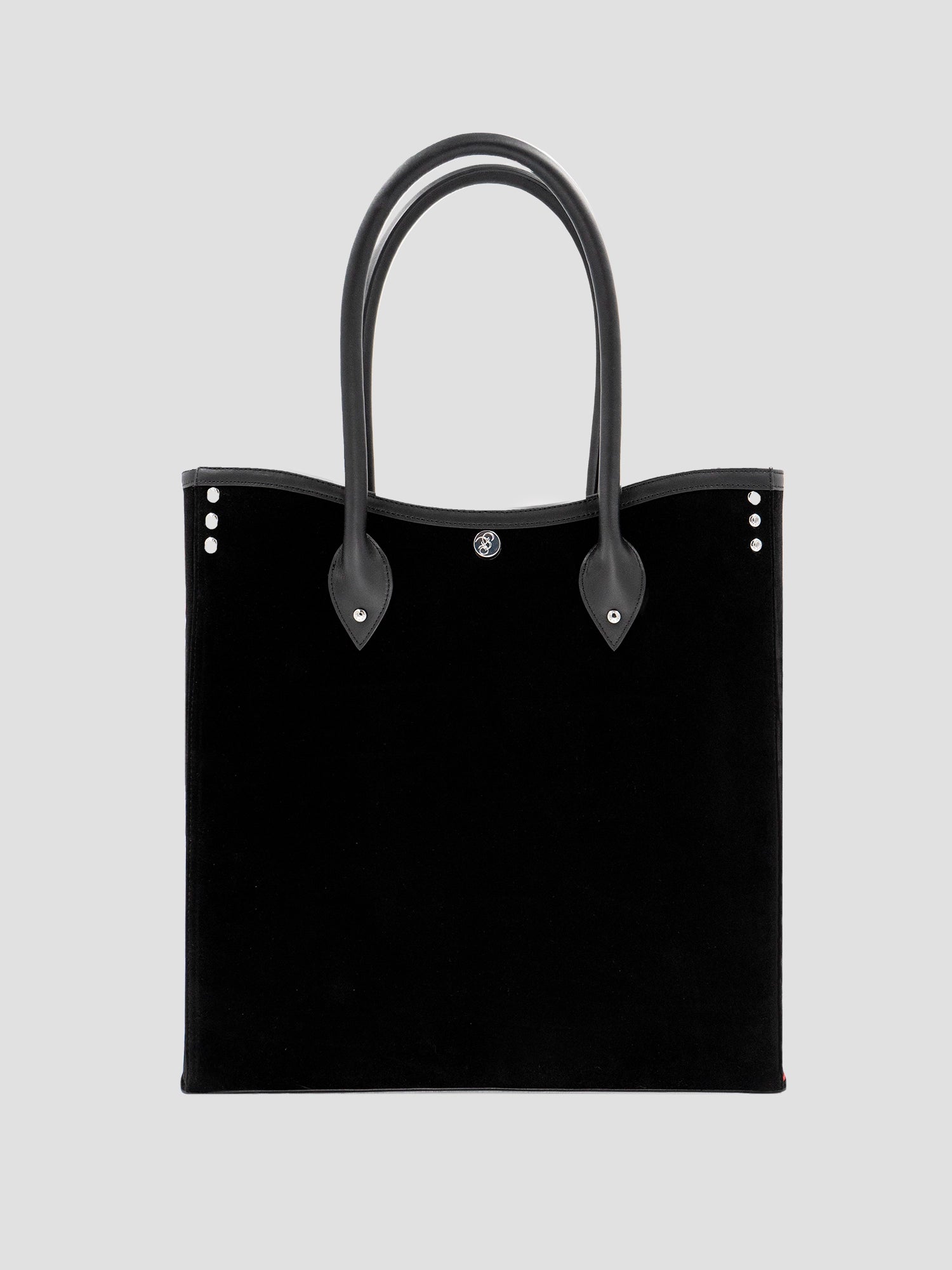 Rear view of the black velvet and leather tote bag with plain black panel and handles.