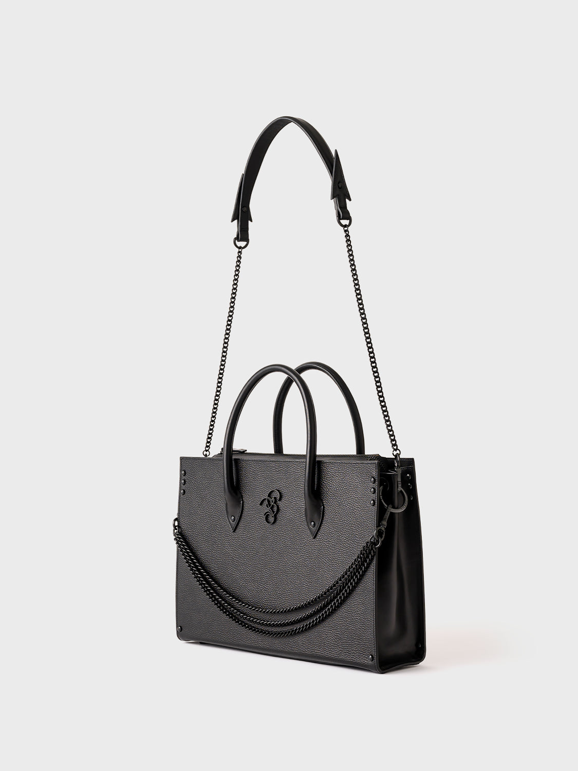 A black leather business bag with a structured design, featuring a padded compartment for laptops, an internal zip pocket, and additional pockets for tablet and accessories. It includes a removable brass chain and a detachable shoulder strap.