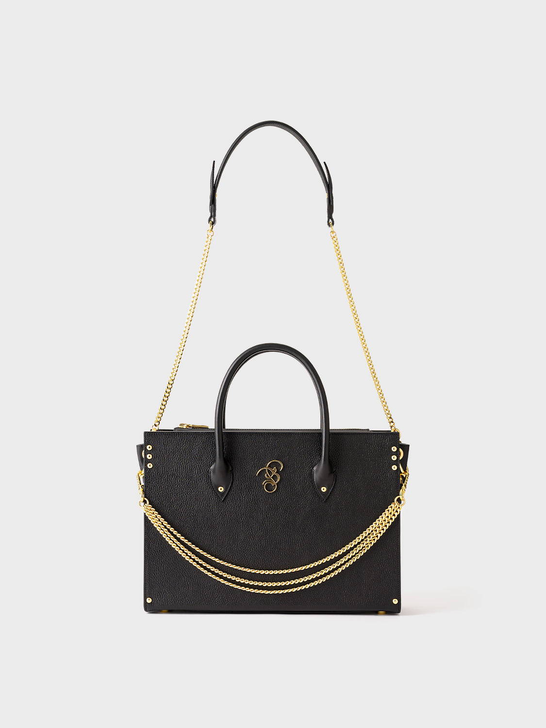 Rear view of a black handbag with a gold chain strap ad gold details.