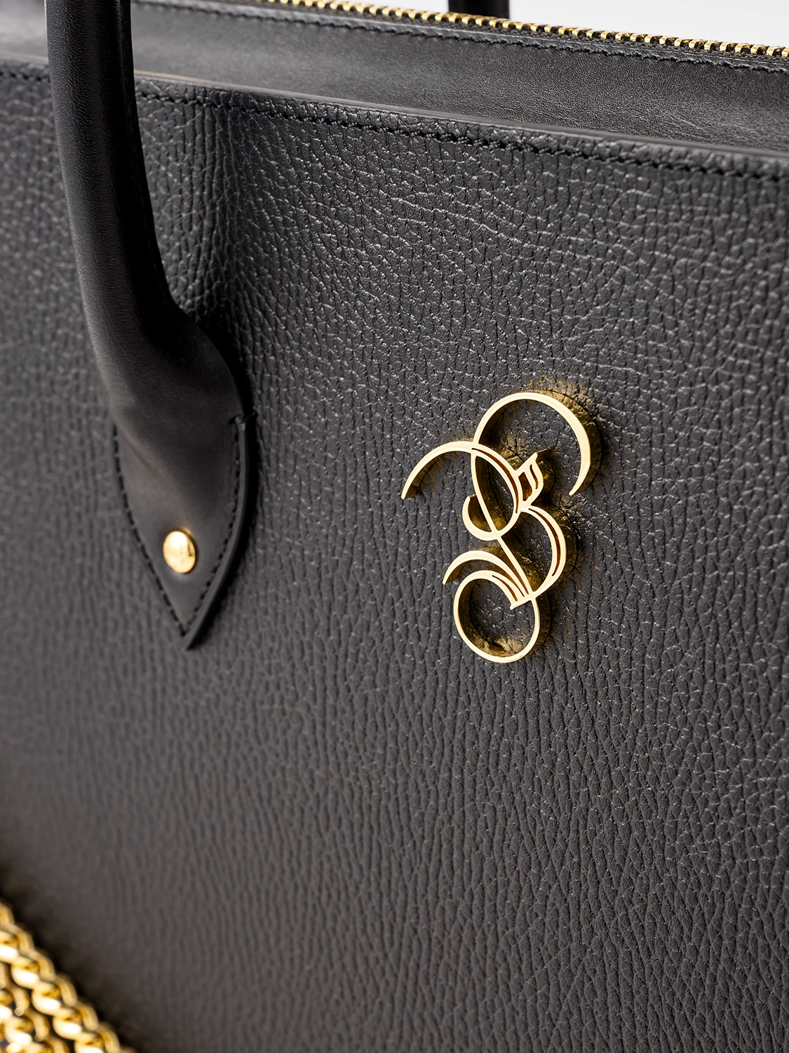 Close-up of a black bag featuring a gold B&B logo.