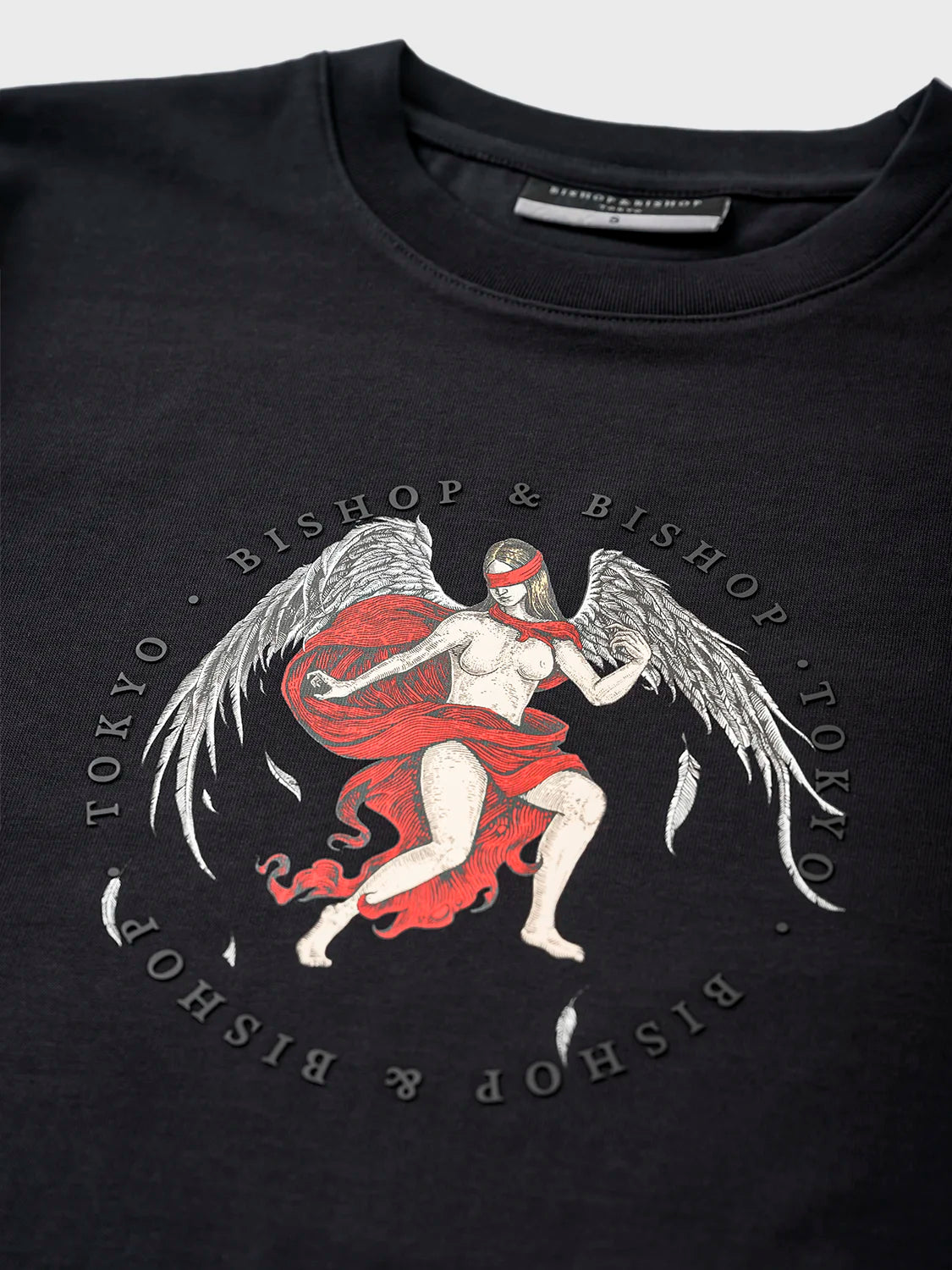 Black T-shirt featuring an angel with wings and a red blindfold graphic, encircled by the text “Bishop & Bishop Tokyo.”