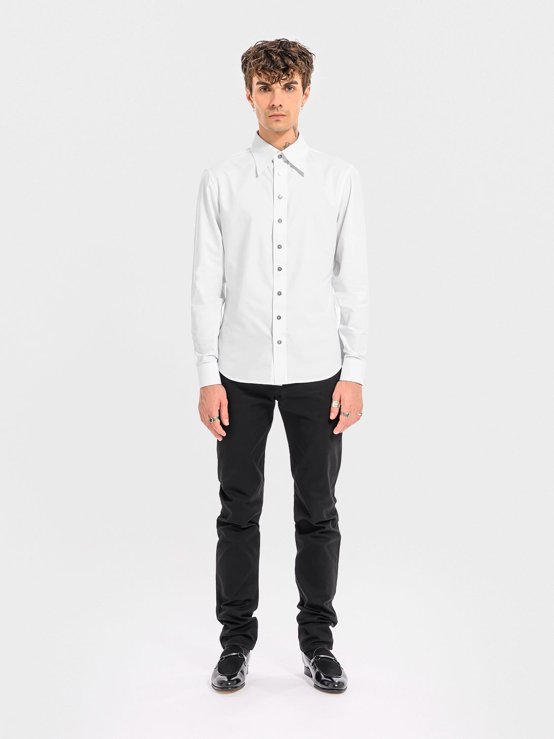 Man wearing a white shirt and black pants on a white background