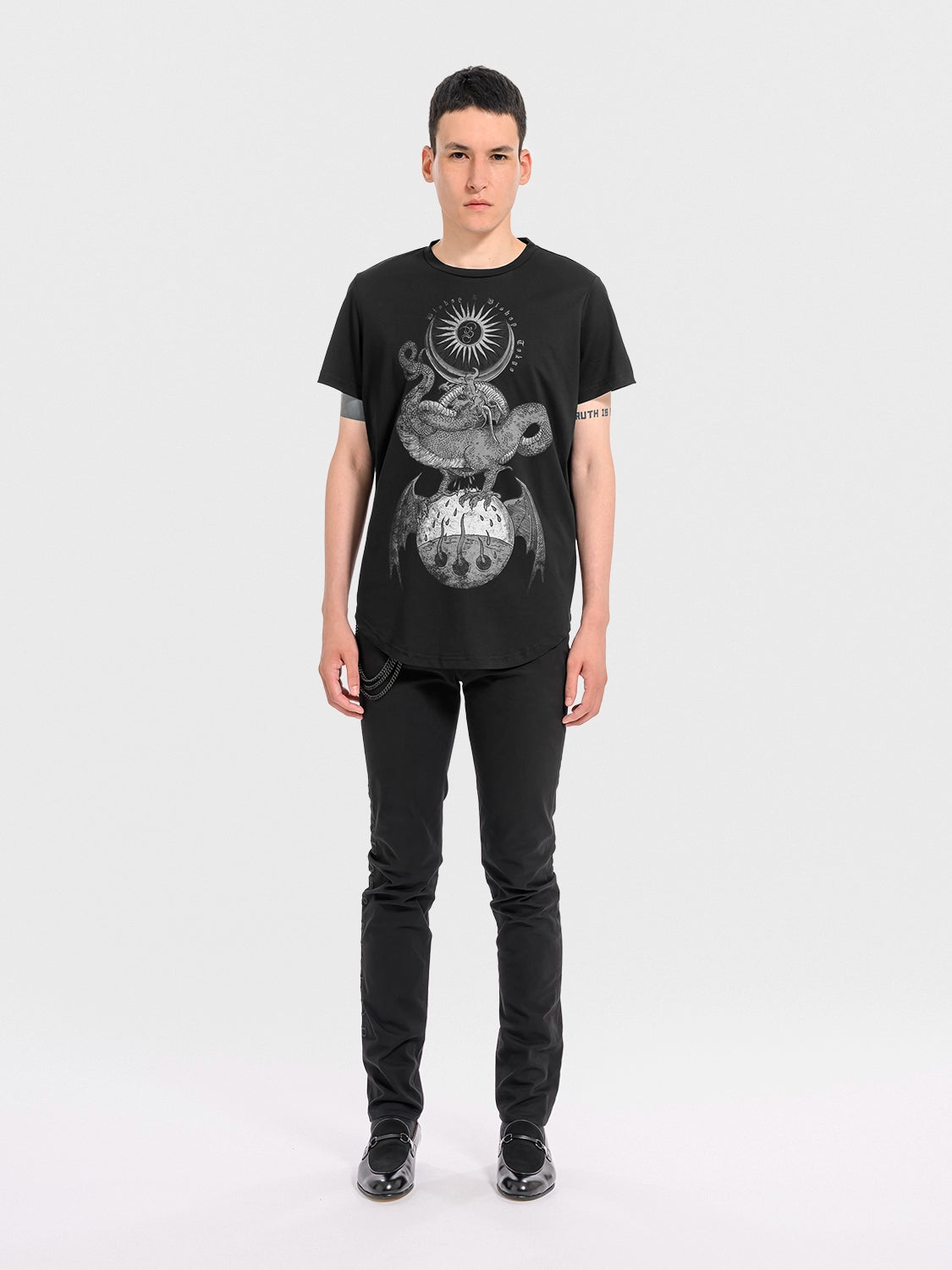 Person wearing a black cotton 'Rebirth' T‑shirt with a graphic design on a white background