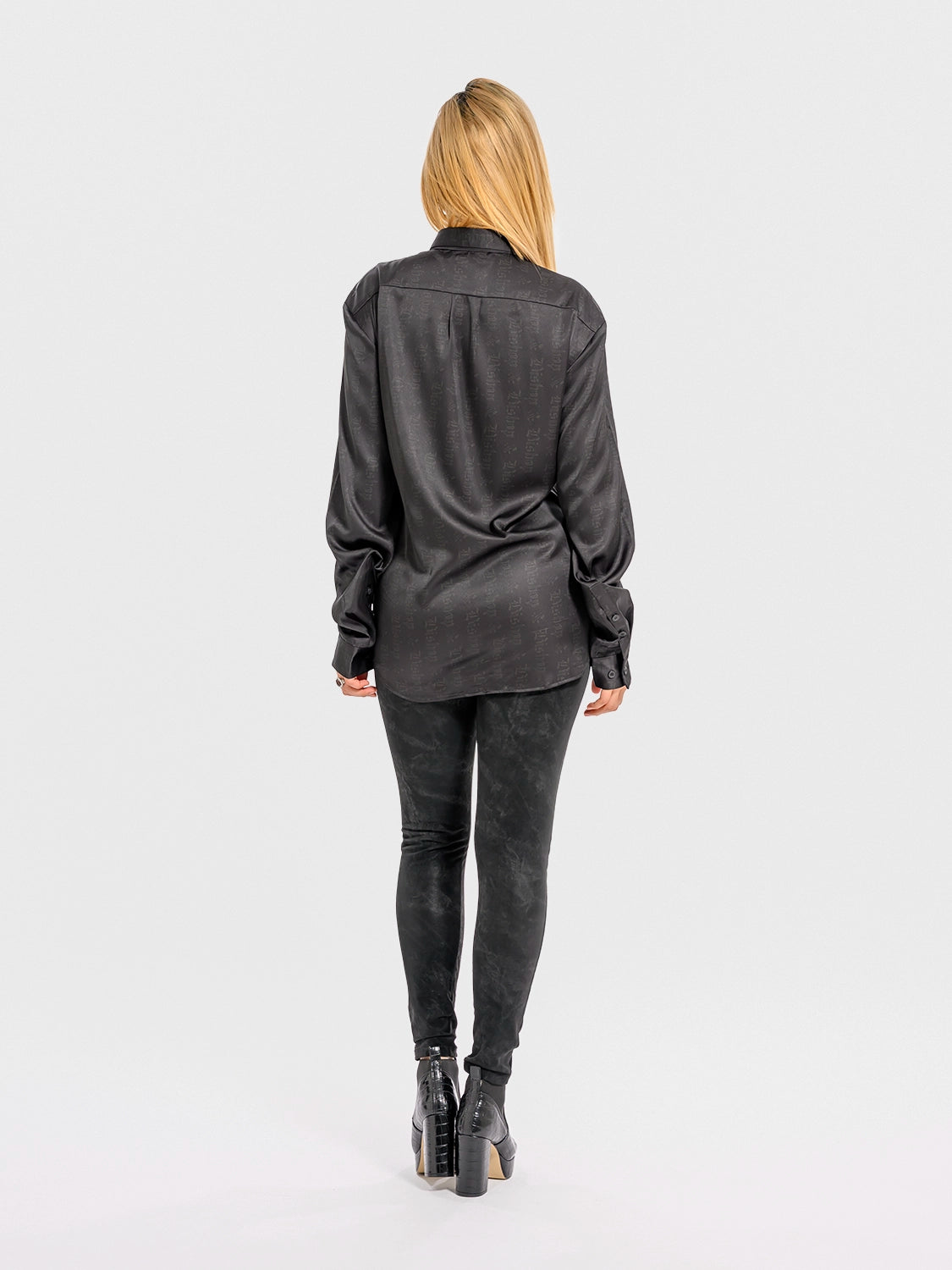 Person wearing a black shirt and pants on a white background