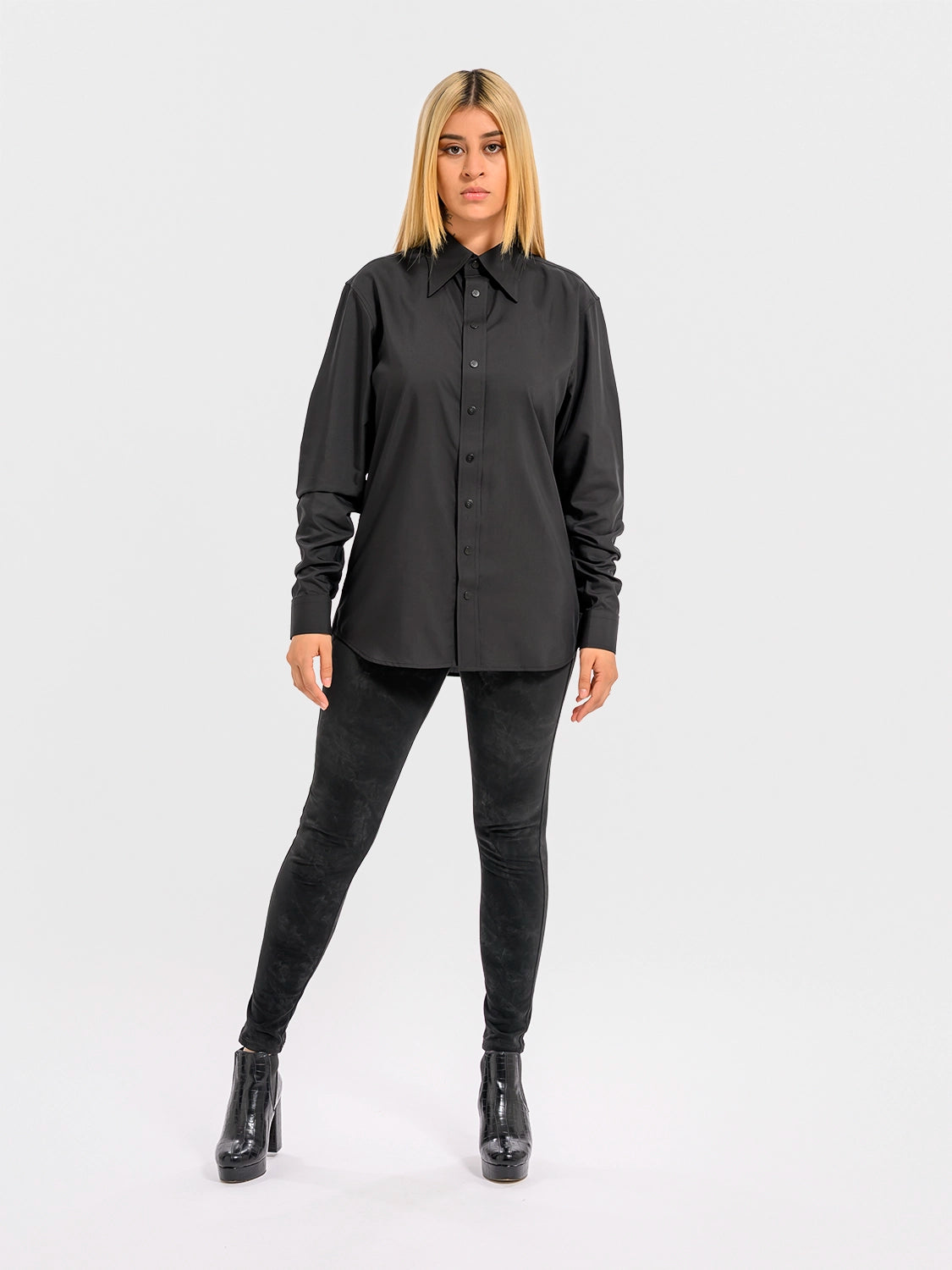 Person wearing a black shirt and pants on a white background