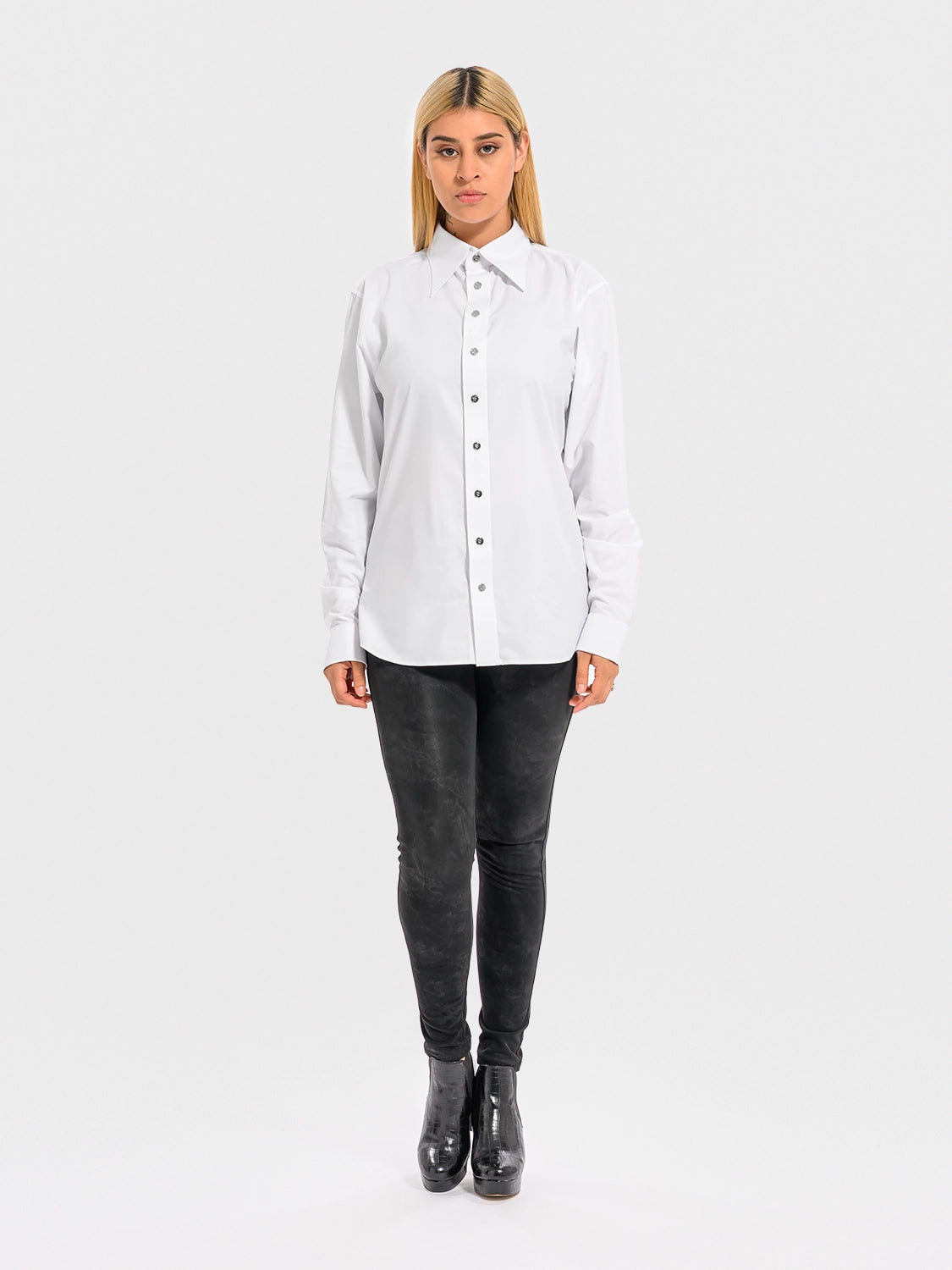 Person wearing a white shirt and black pants on a white background