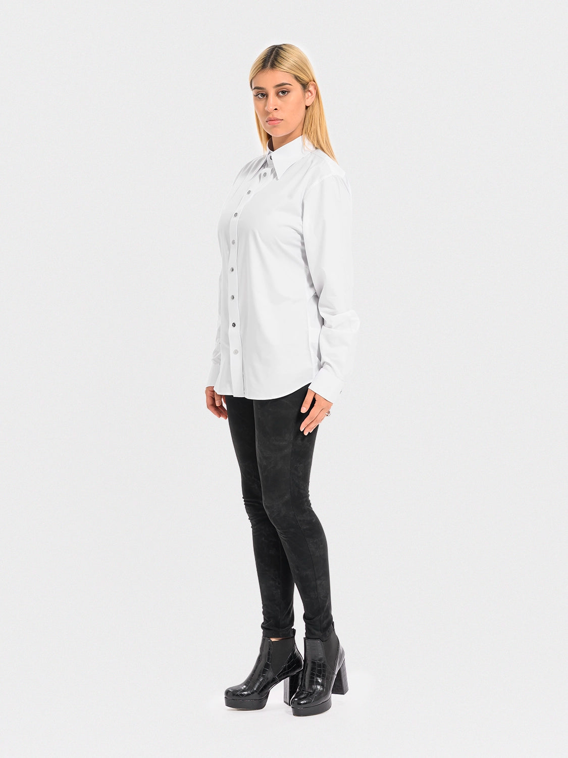 Woman wearing a white shirt and black pants on a white background