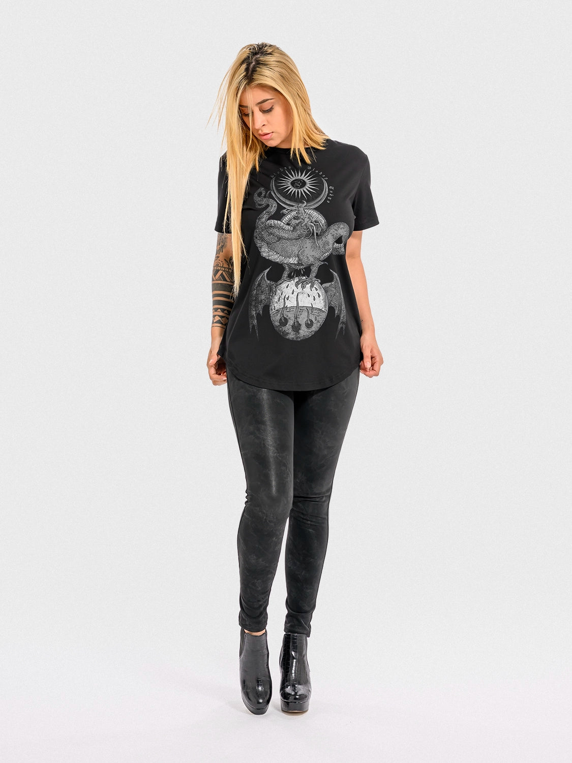 Woman wearing a black cotton 'Rebirth' T‑shirt with a graphic design on a white background
