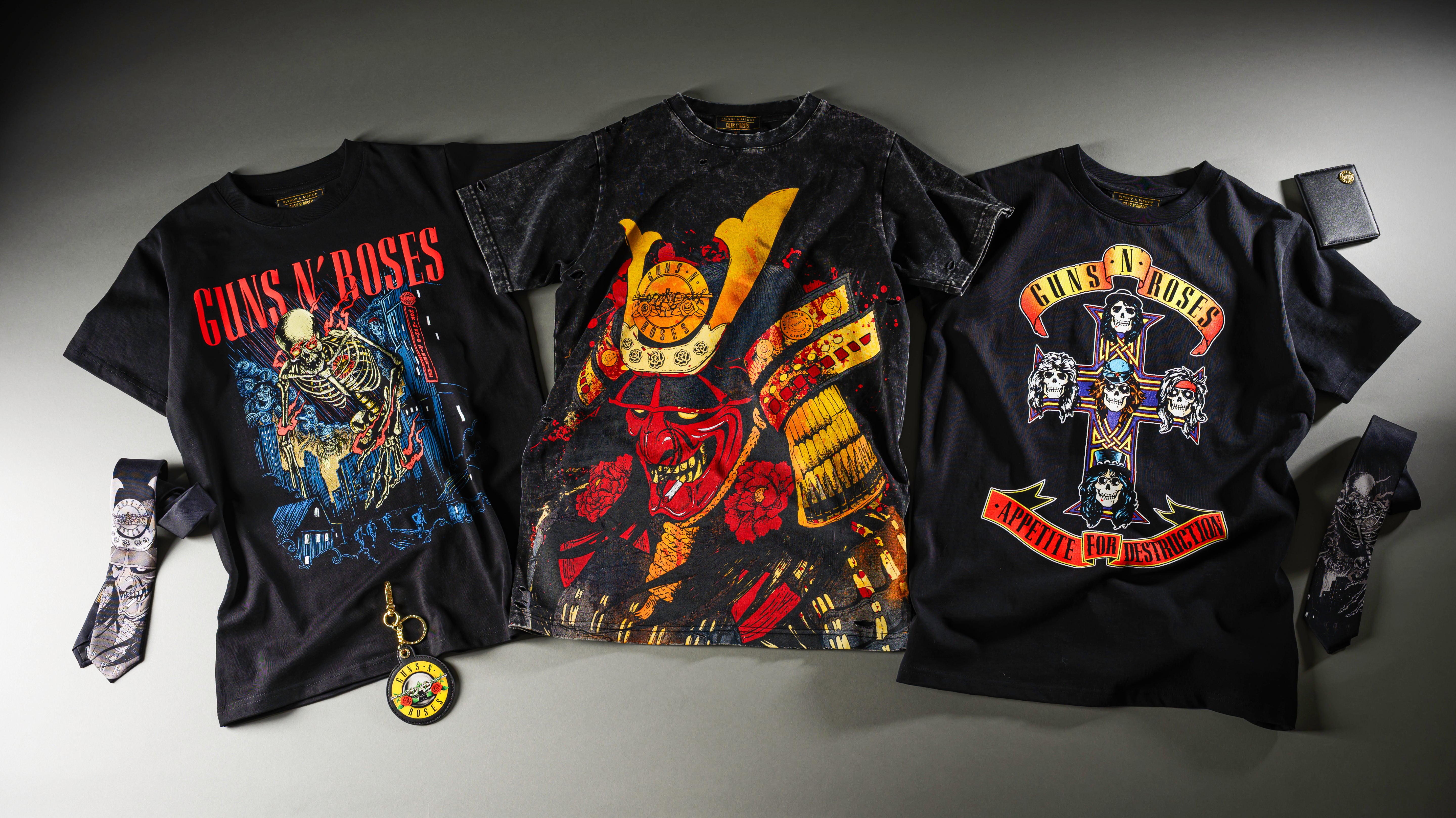 Three black Guns N' Roses t-shirts with colorful graphics and text on a gray background