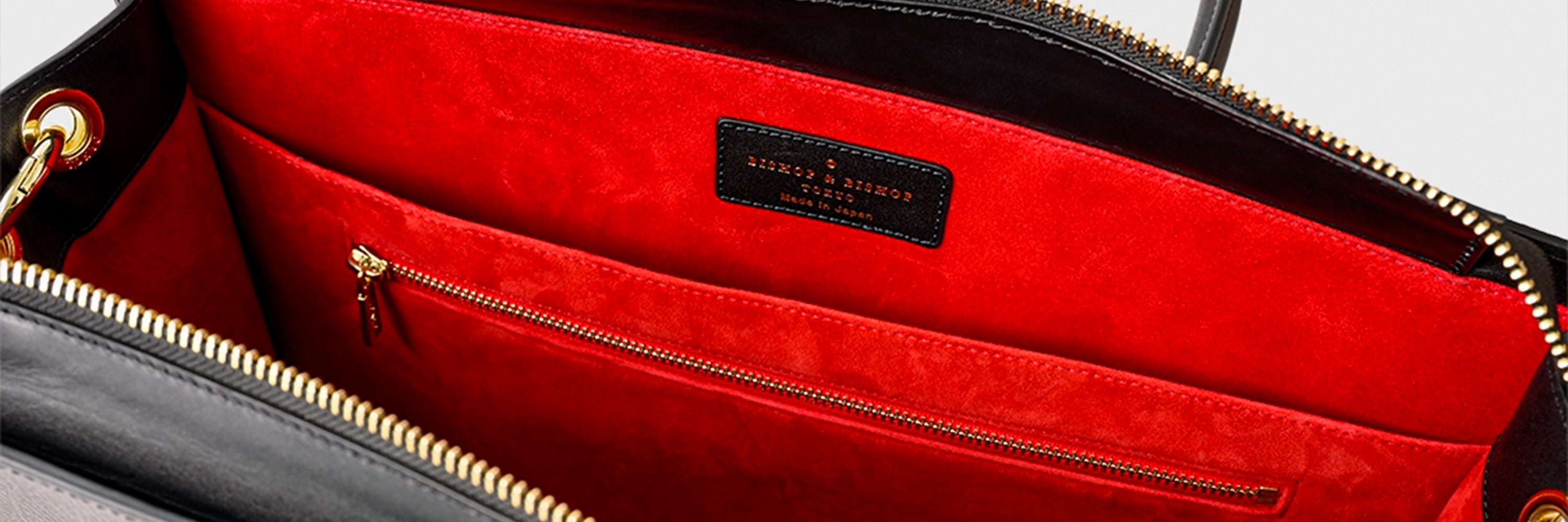 Close-up of the interior of a black bag, showing red lining.