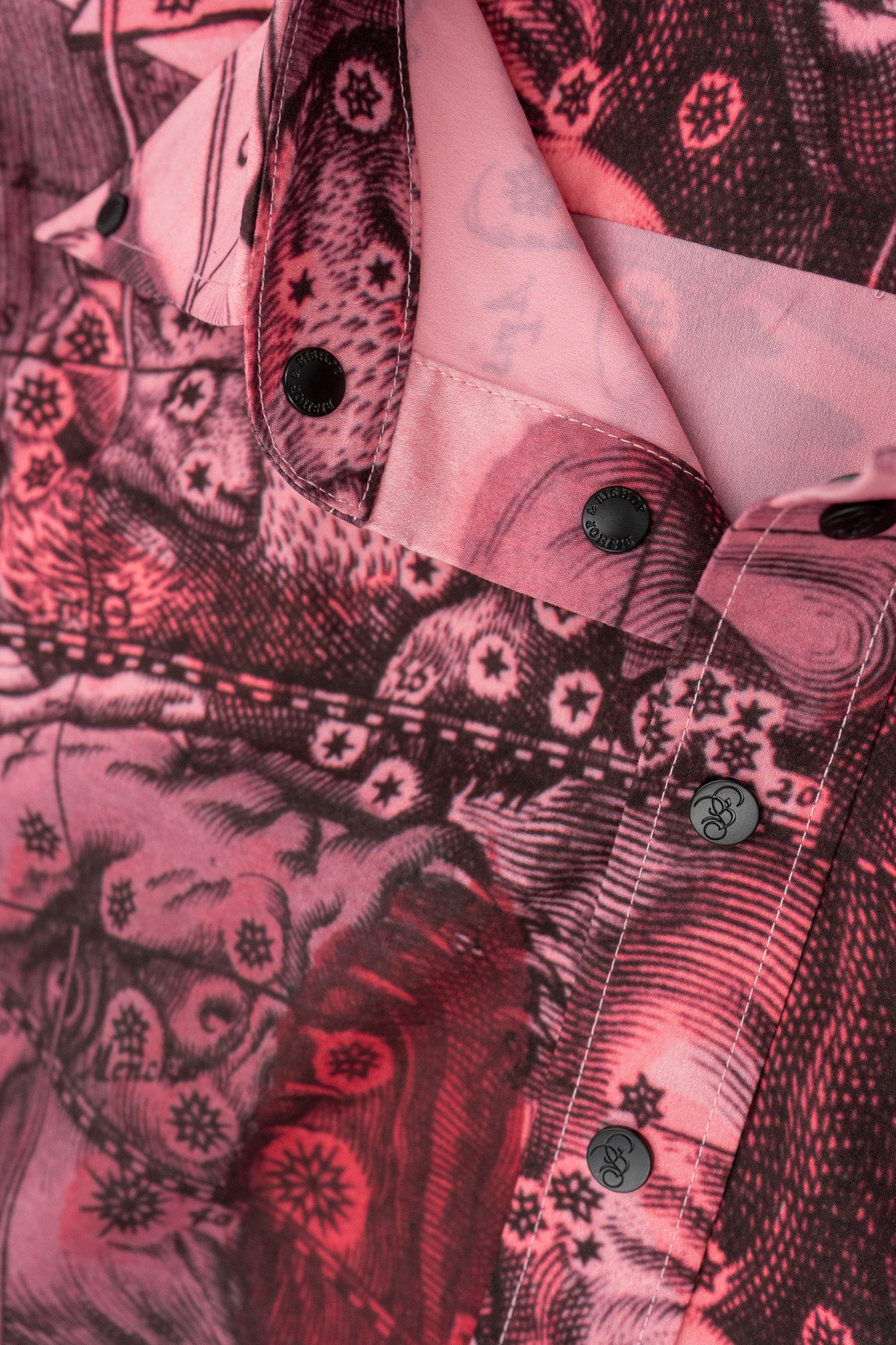 Close-up of thepink silk shirt, highlighting the intricate pattern and smooth silk texture.