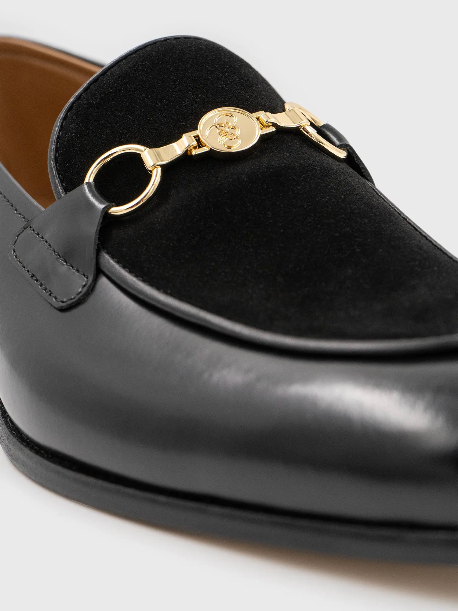 Close-up of a black shoe with gold detailing