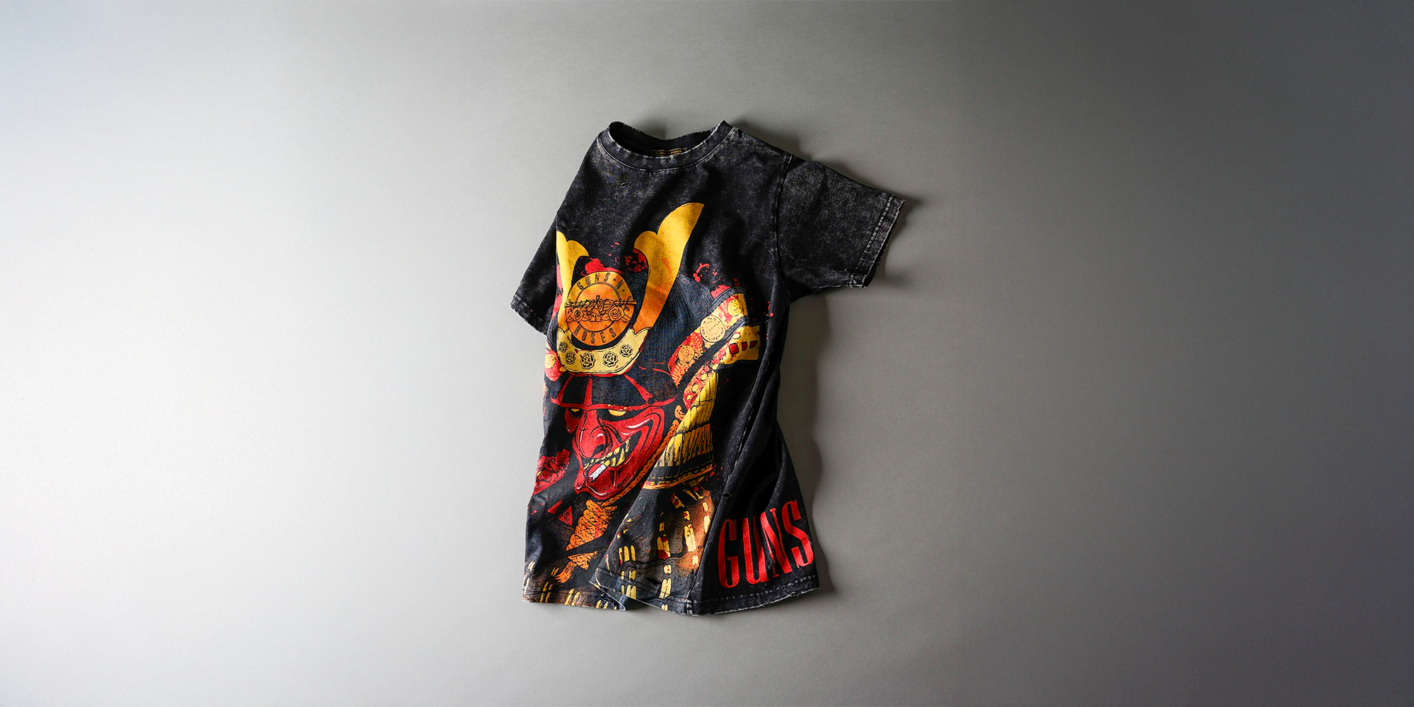 Black t-shirt with colorful graphic design on a gray background