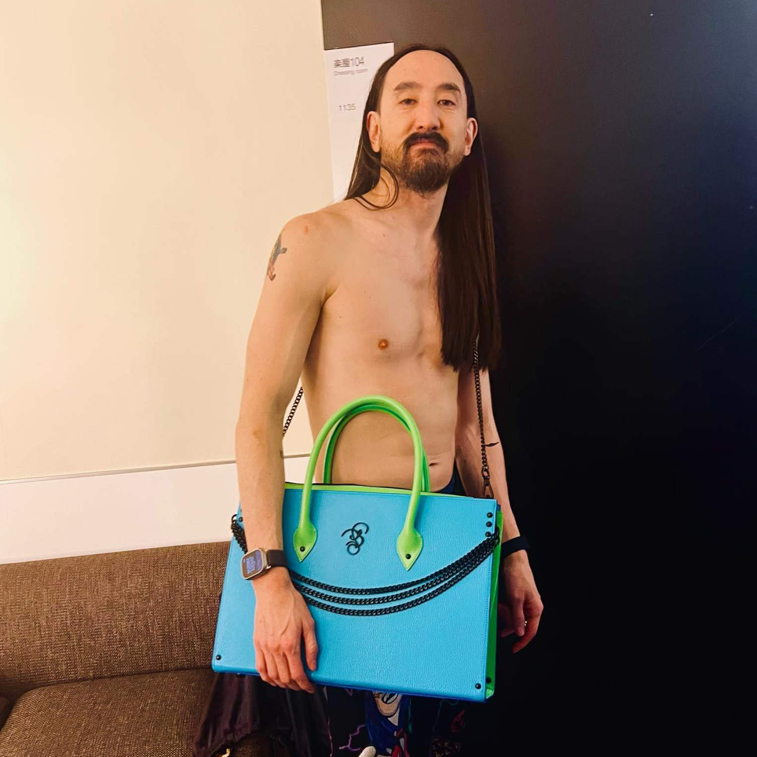 Front view of Steve Aoki holding the custom Andrew Lee laptop bag, showcasing premium materials, detailed craftsmanship, and the unique design created for his exclusive Bishop & Bishop collection.