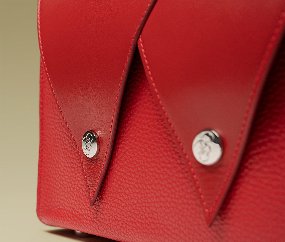 Close-up of a red bag with silver buttons.