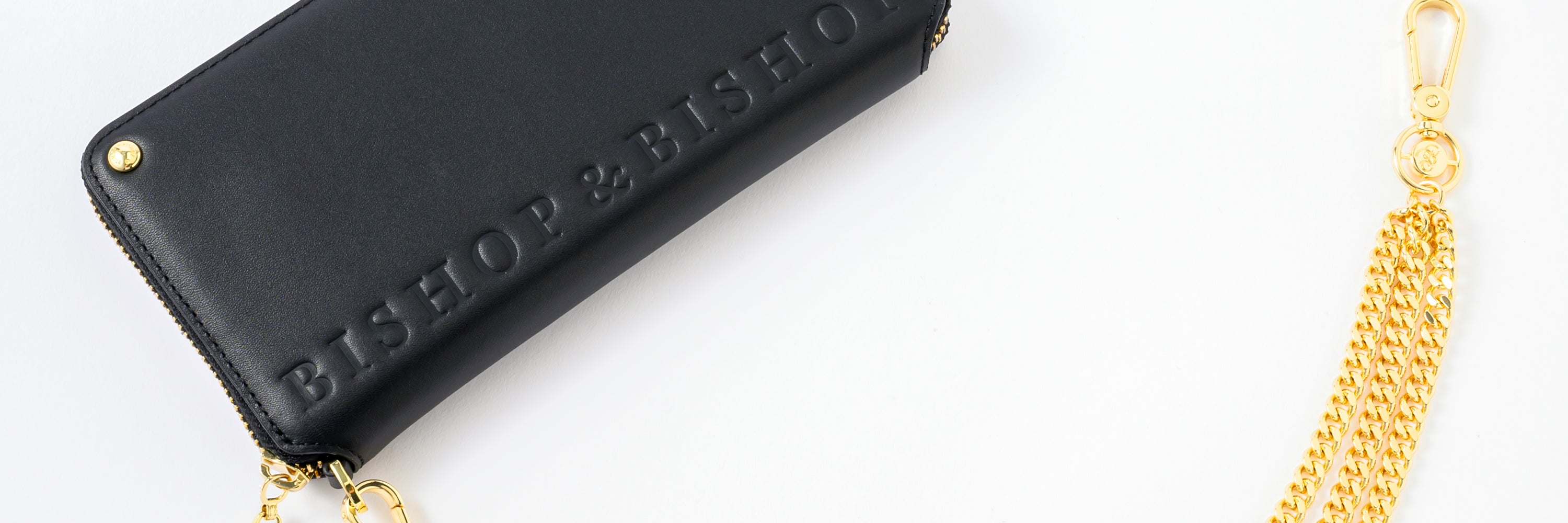 Black wallet with a gold zipper, featuring an embossed “Bishop & Bishop” logo at the bottom.