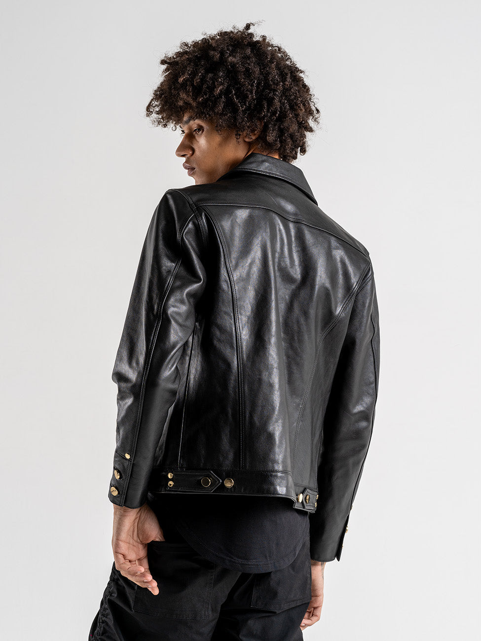 Man wearing a black leather jacket, shown from the back.