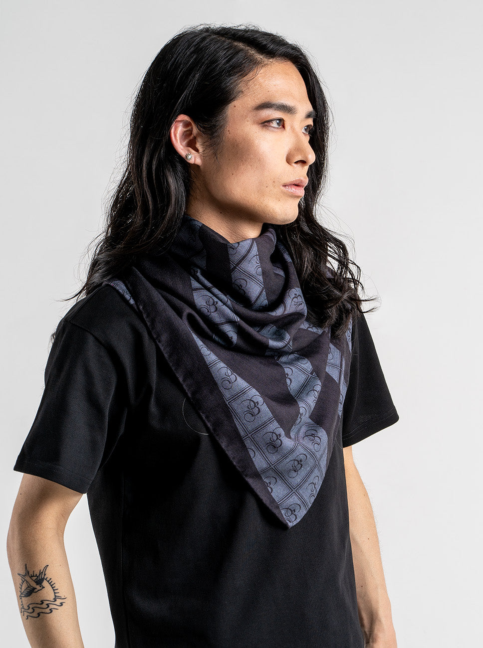 Person wearing a black and charcoal zebra print stole with the Bishop & Bishop monogram woven into the fabric.