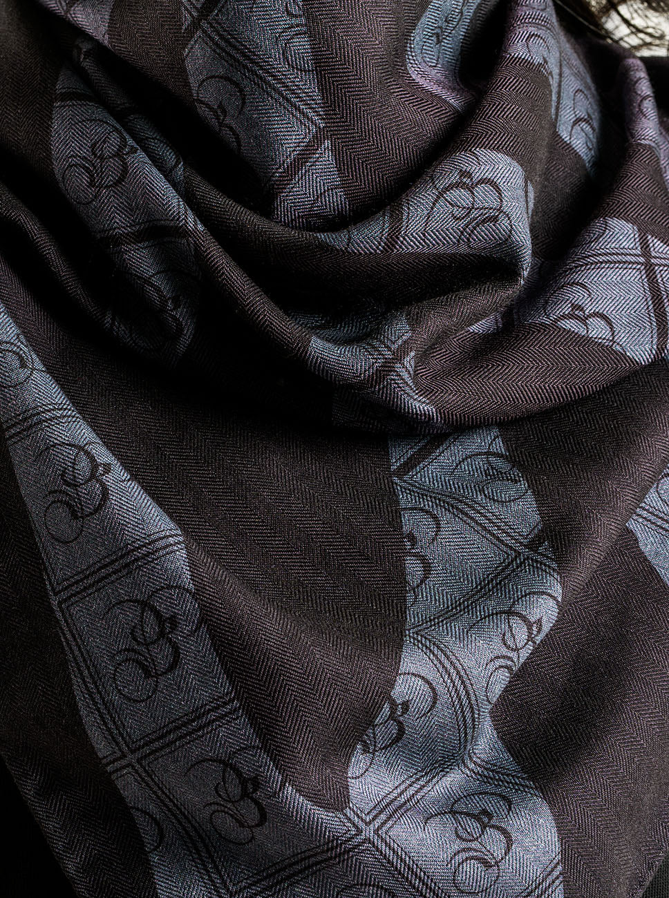 A black and charcoal zebra print stole with the Bishop & Bishop monogram woven into the fabric.