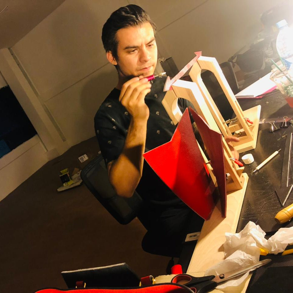 Image of Erik engaged in the design process, focused on creating a garment by hand.