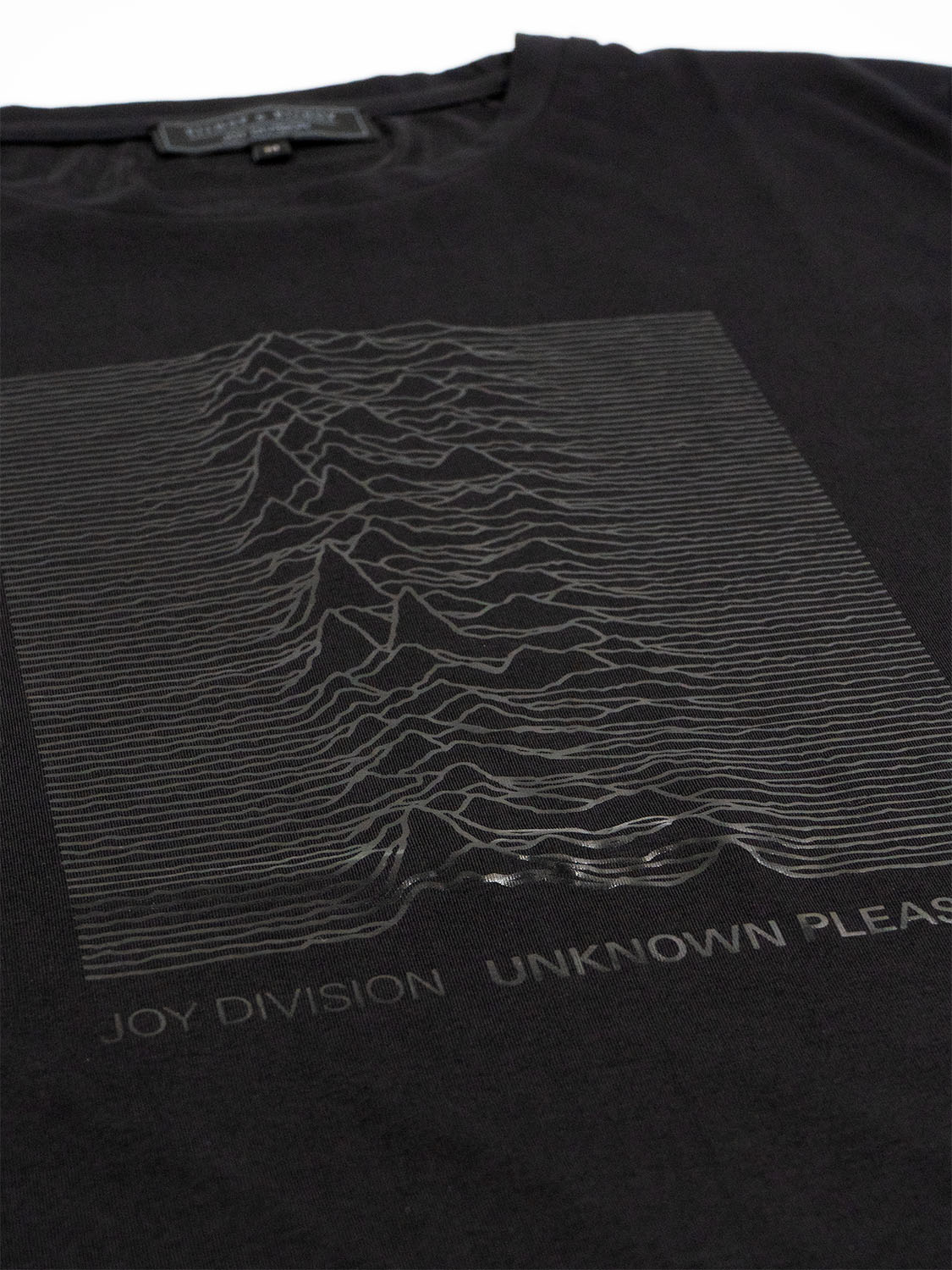 Close-up of the black foil graphic on the front of the T-shirt showing fine texture and detail.