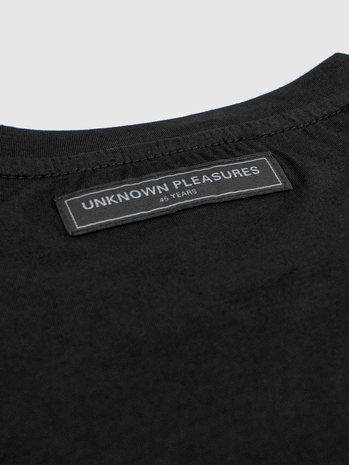 Close-up of the inner back collar with a woven Joy Division label stitched into the neckline.