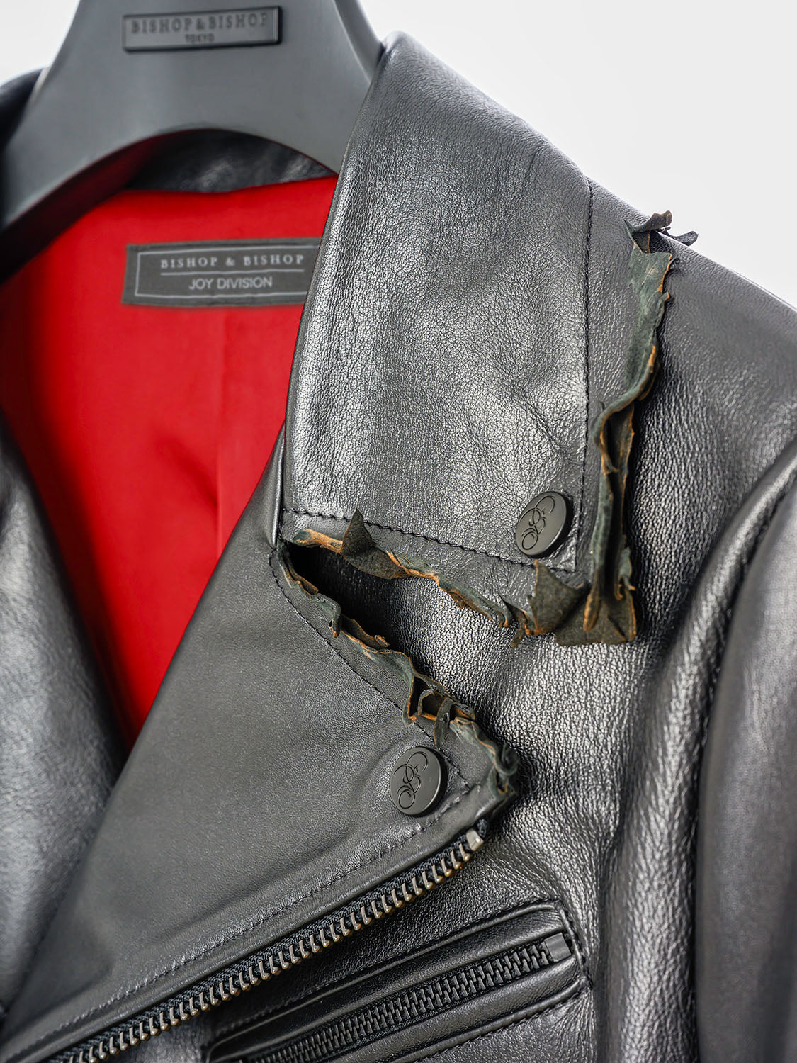 Macro detail of the inner collar showing the red silk lining and embossed branding tag.