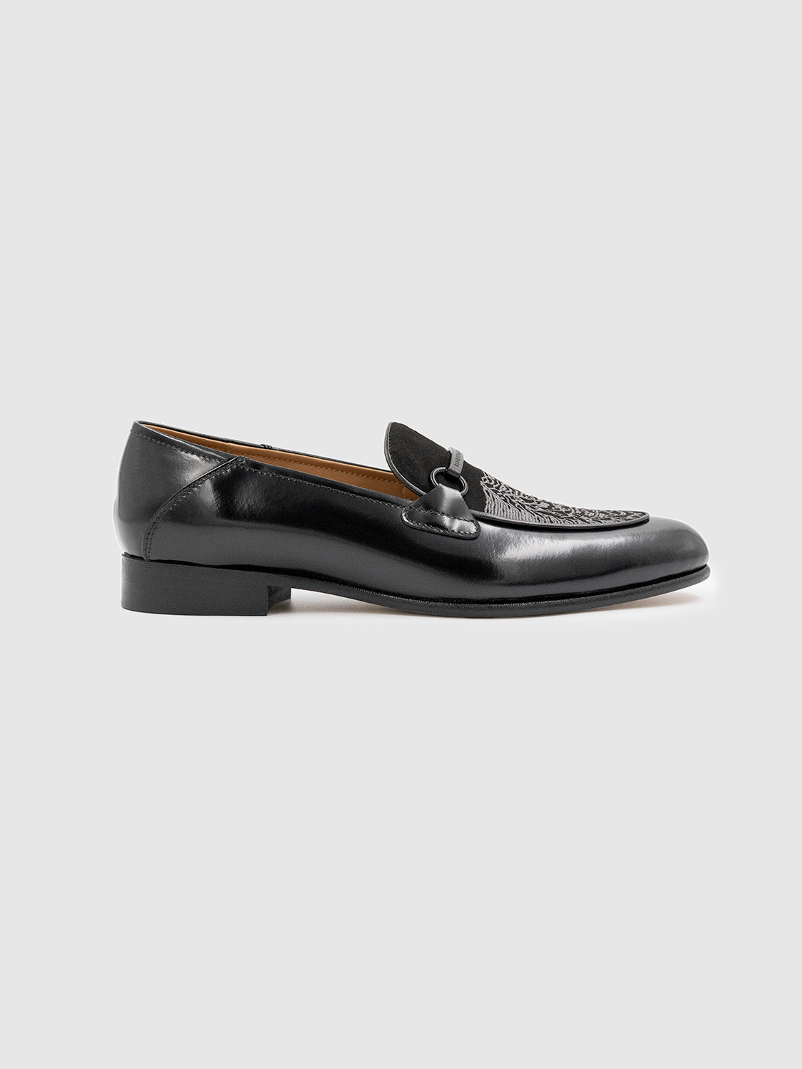 Side view of a single black loafer highlighting its clean silhouette and leather finish.