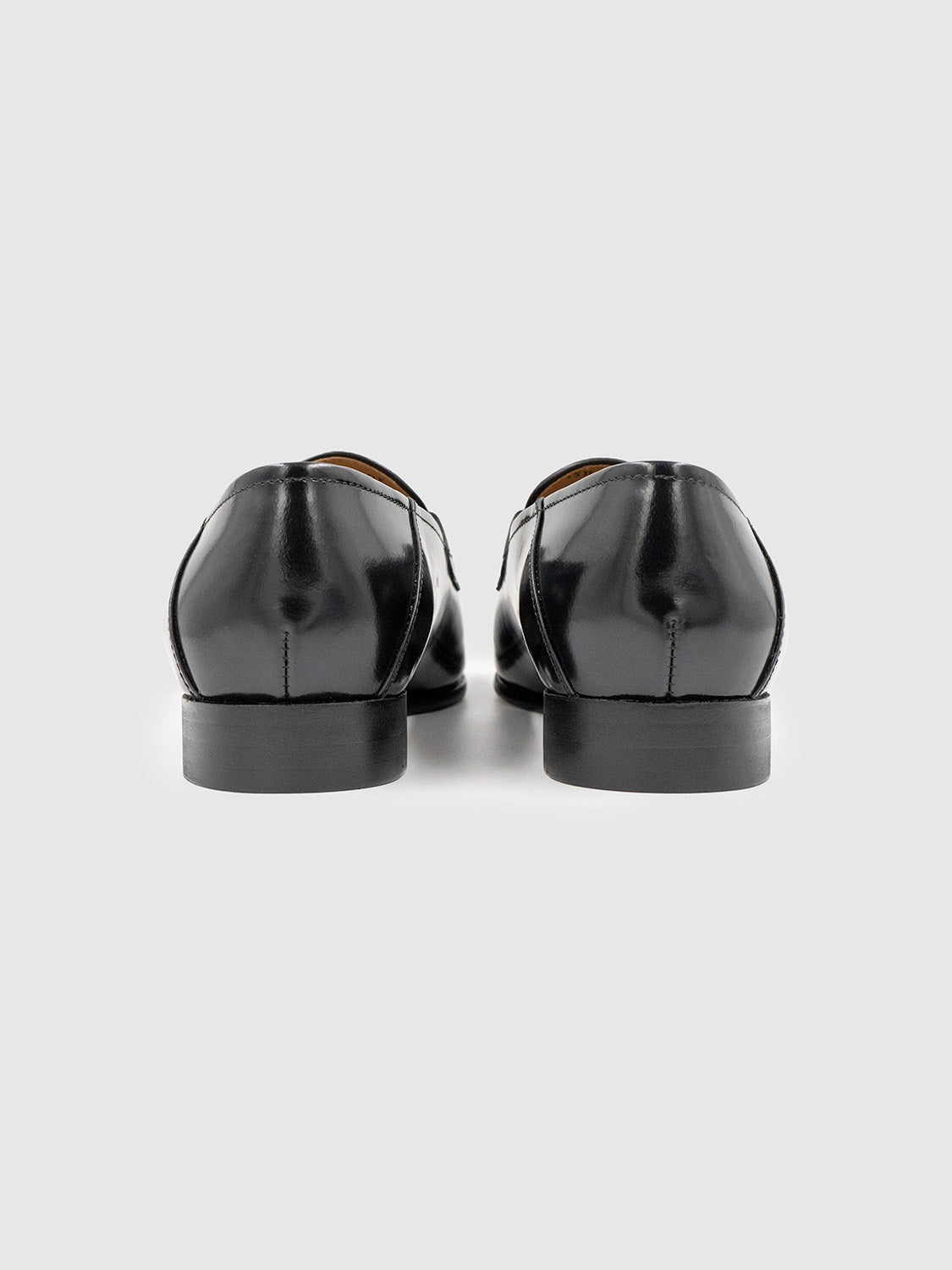 Rear view of the loafers displaying the structured heel and polished leather back.