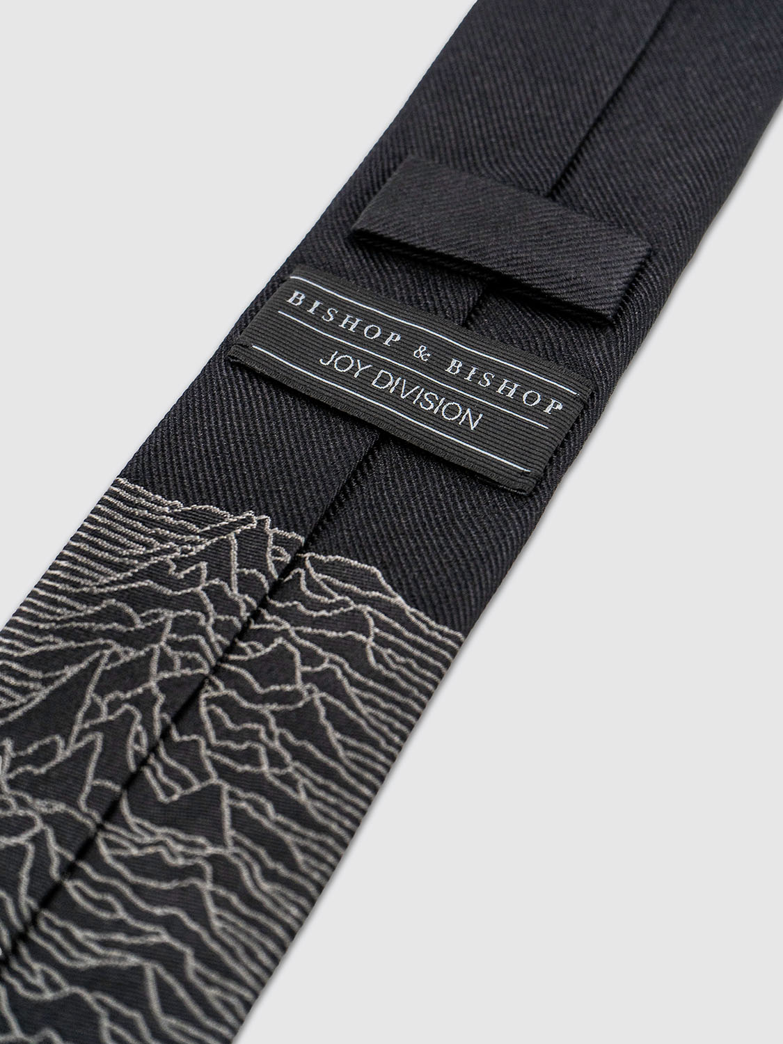 Rear view of the tie showing the loop keeper and the continuation of the jacquard artwork.
