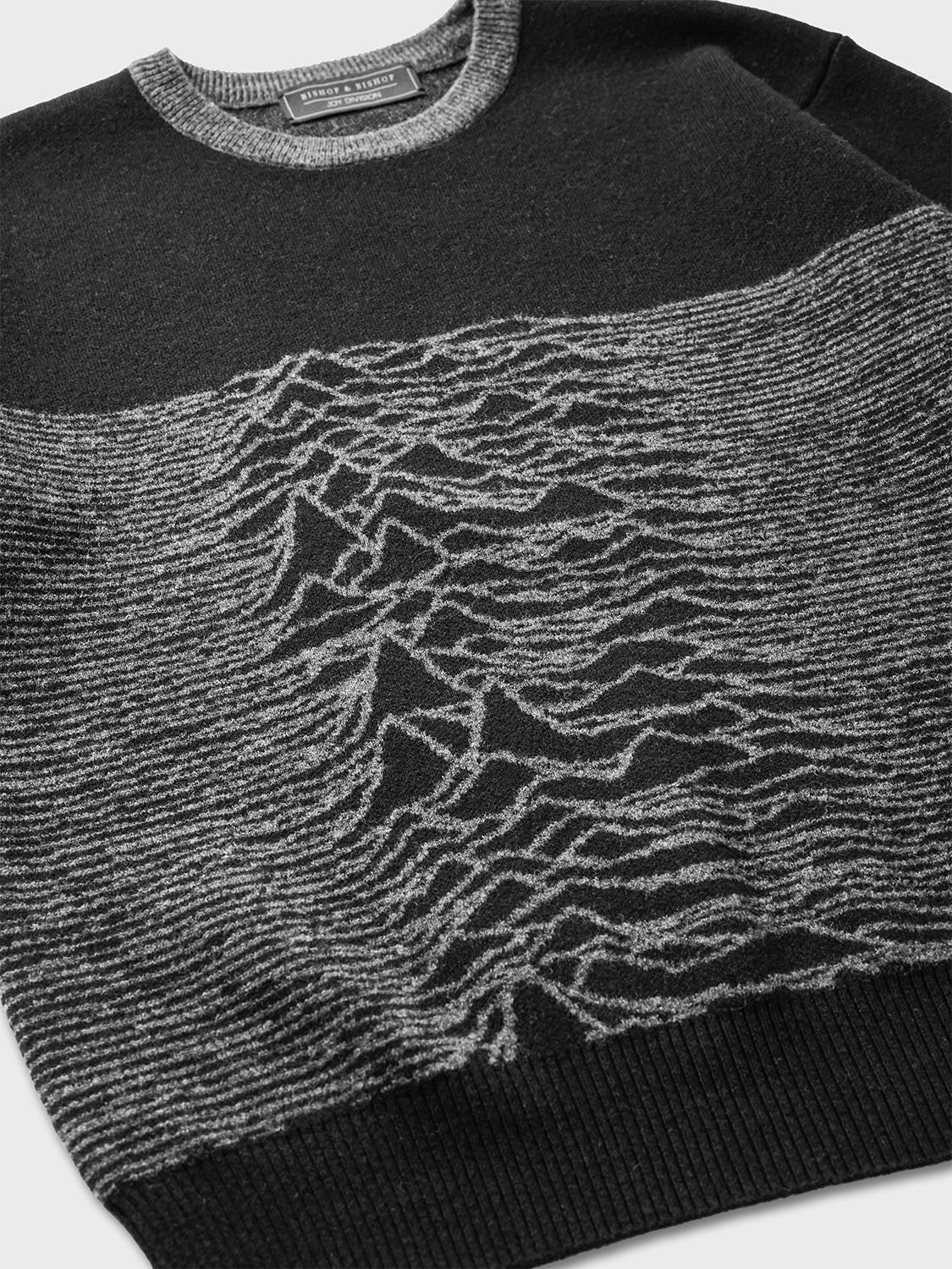 Close-up of the textured waveform knit pattern across the chest of the sweater.