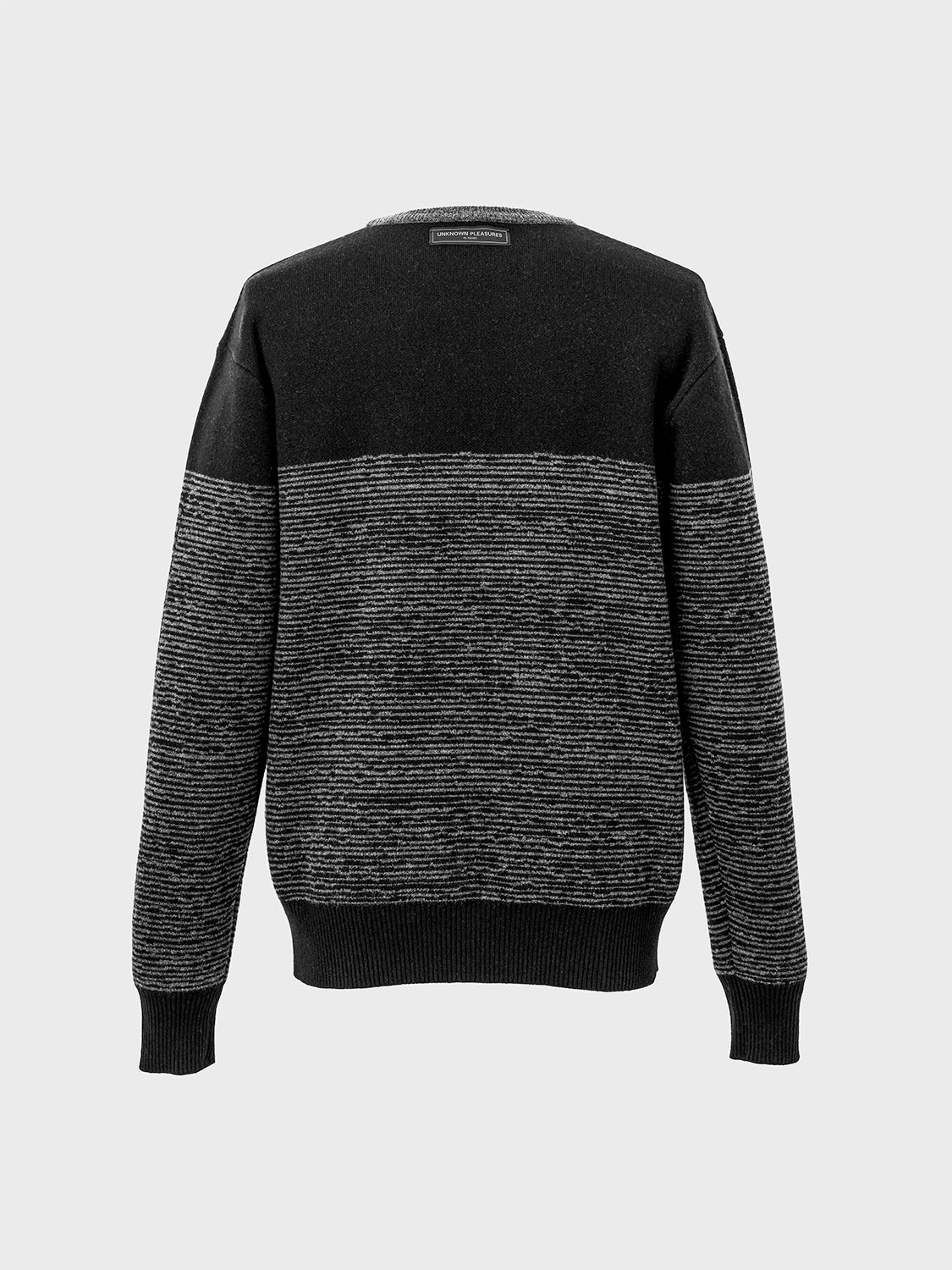 Rear view of the sweater showcasing its two-tone design and relaxed fit.