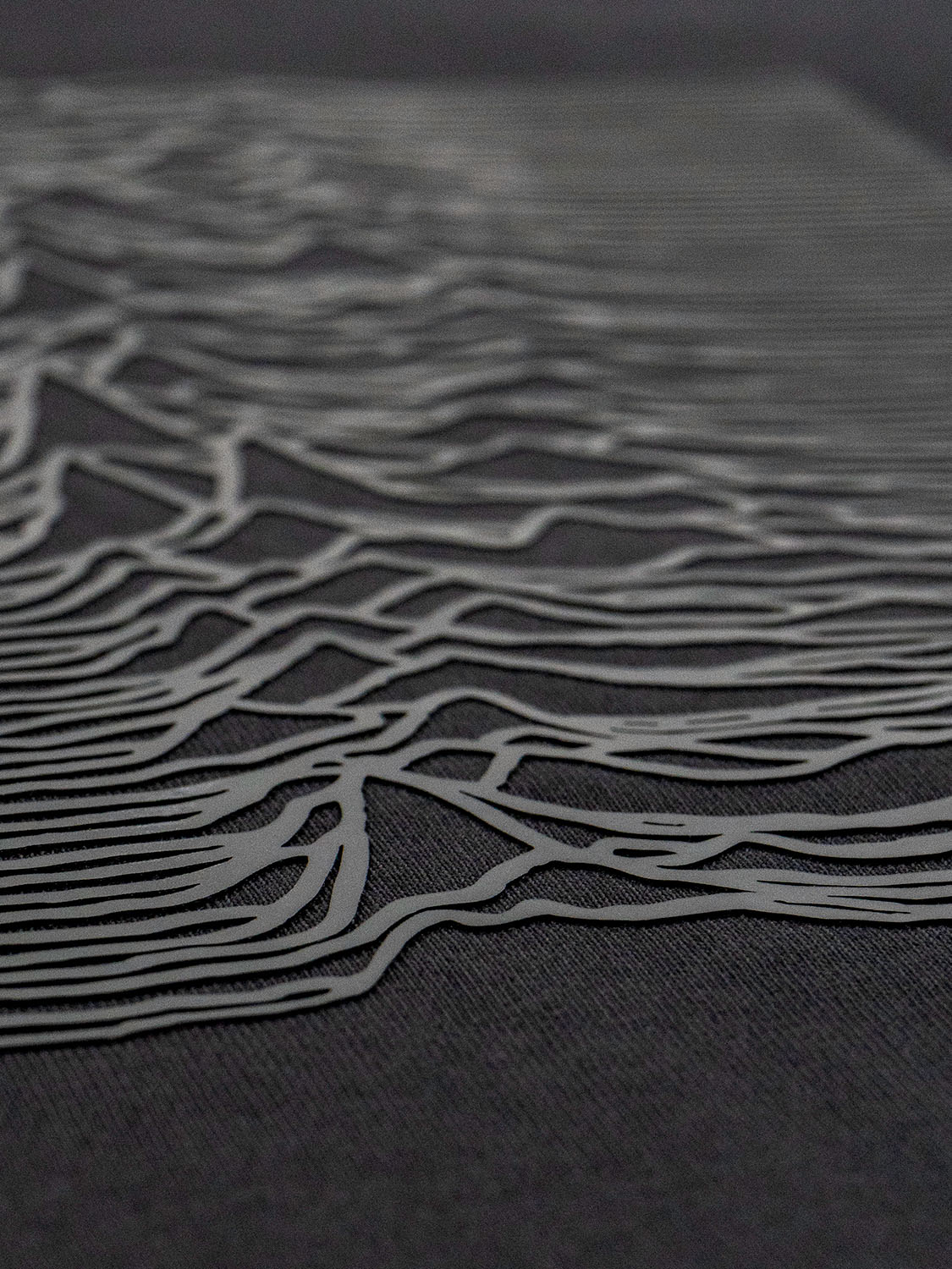 Close-up of the raised grey silicone artwork revealing the depth and detail of the waveform pattern.