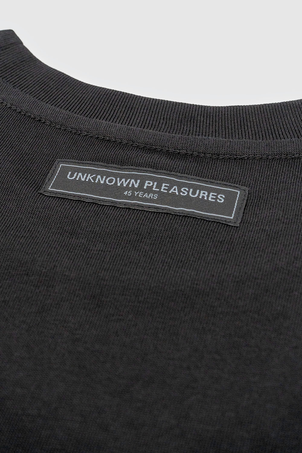 Close-up of the inner collar label stitched into the neckline with tonal branding.