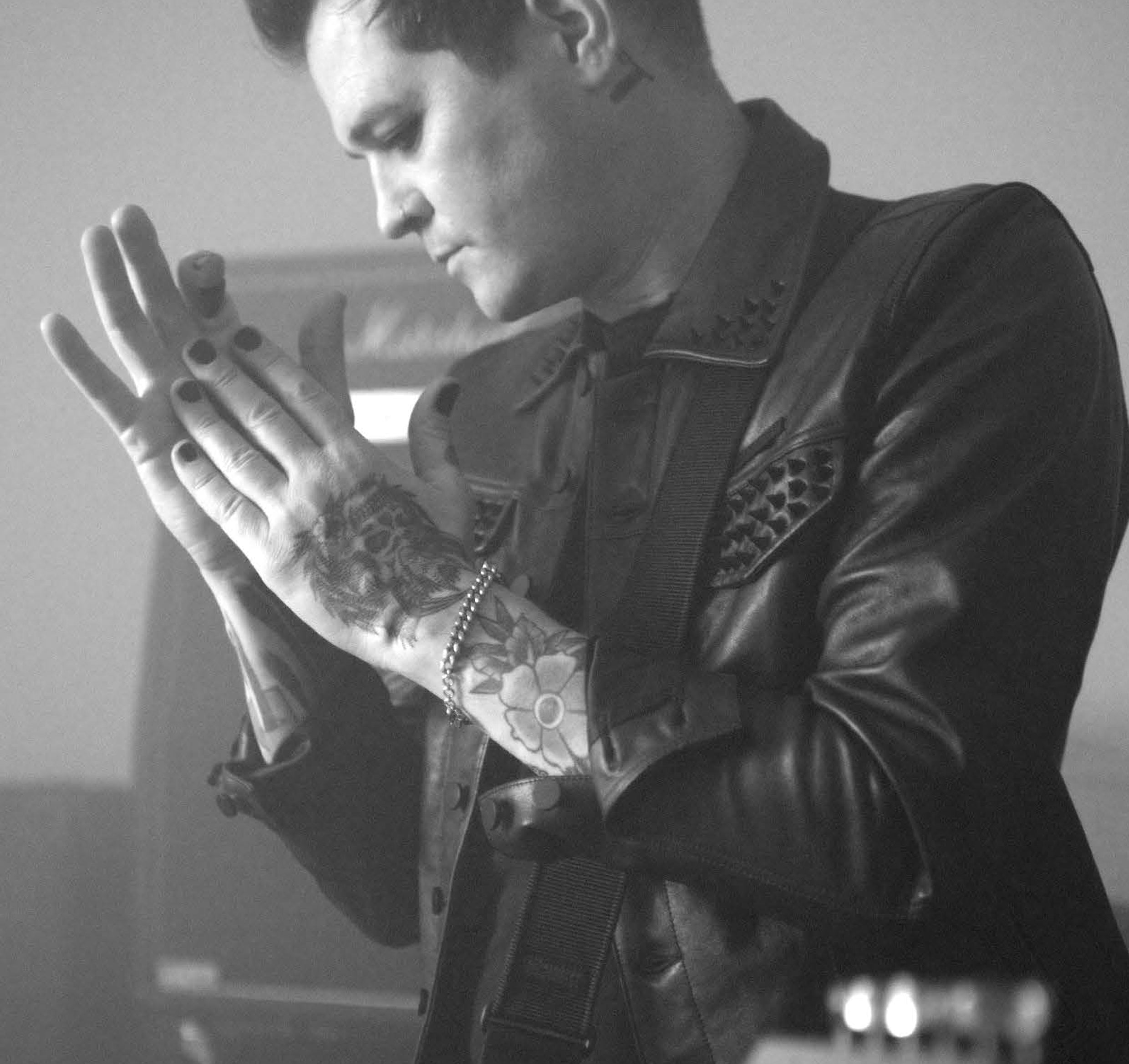 Grey-tone image of Lear Mason wearing the custom black leather trucker jacket, emphasizing its clean lines, premium leather texture, and strong, minimalist silhouette.