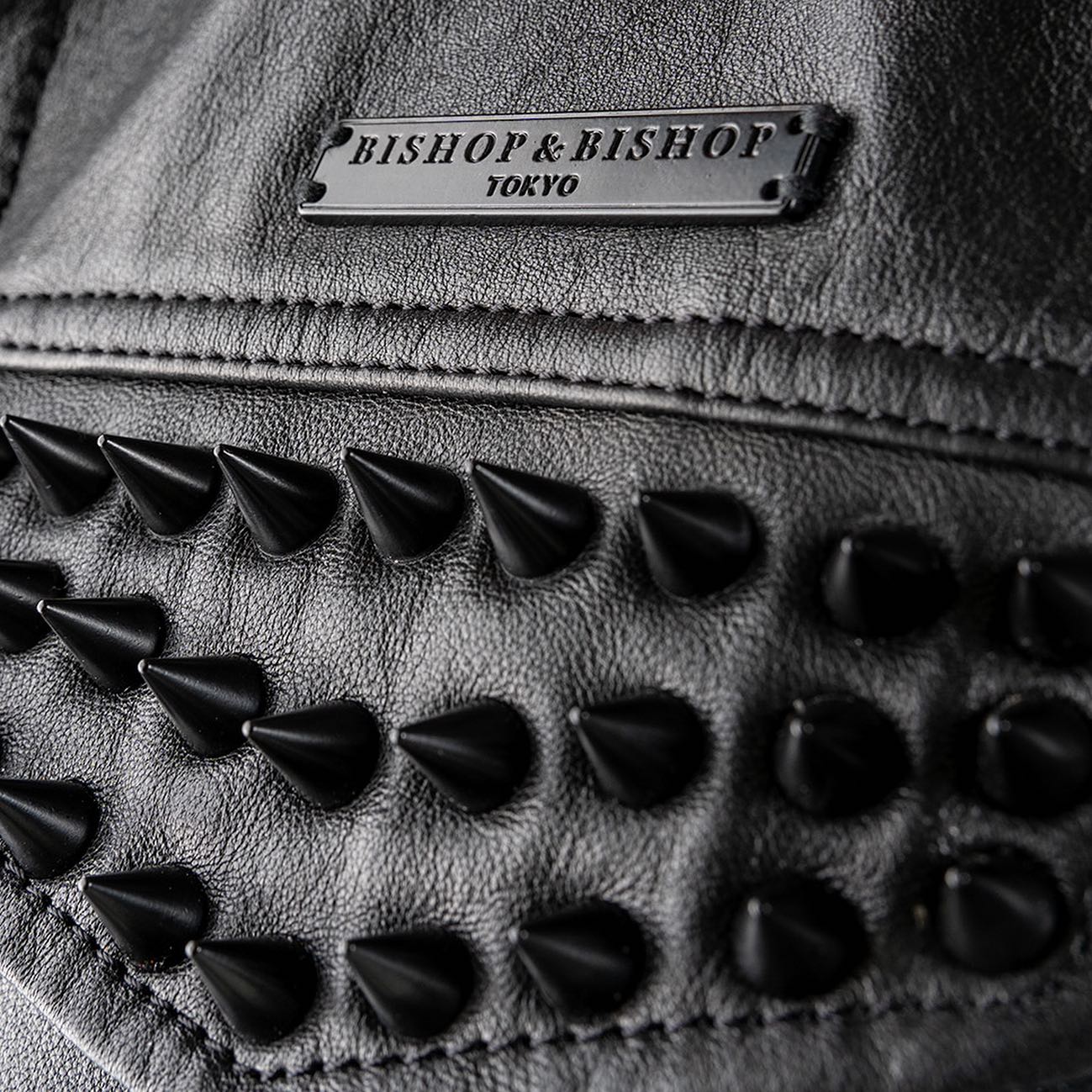 Close-up of black rivets on leather with a Bishop & Bishop tag.