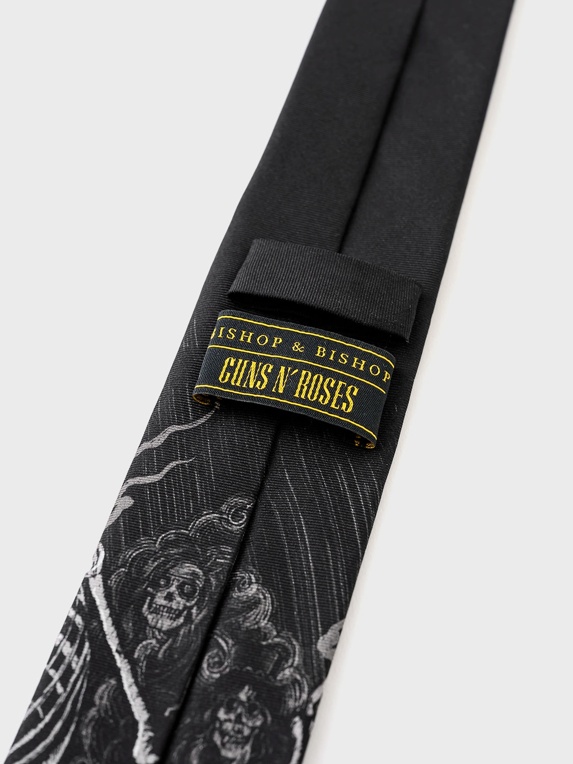 Black tie with skull design and 'Bishop & Bishop Guns N' Roses' label on a white background