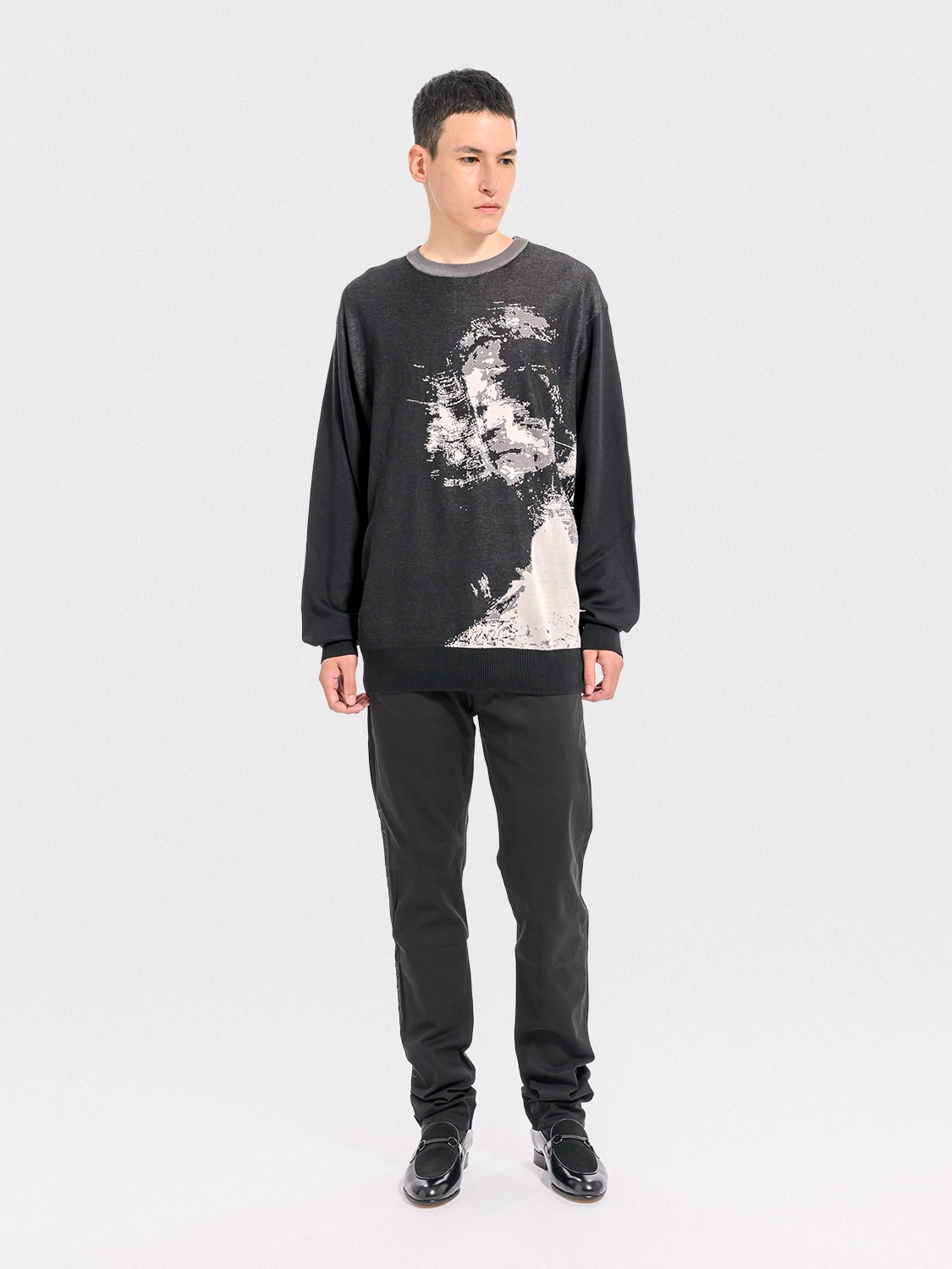 Person wearing a black sweatshirt with a graphic design on a white background