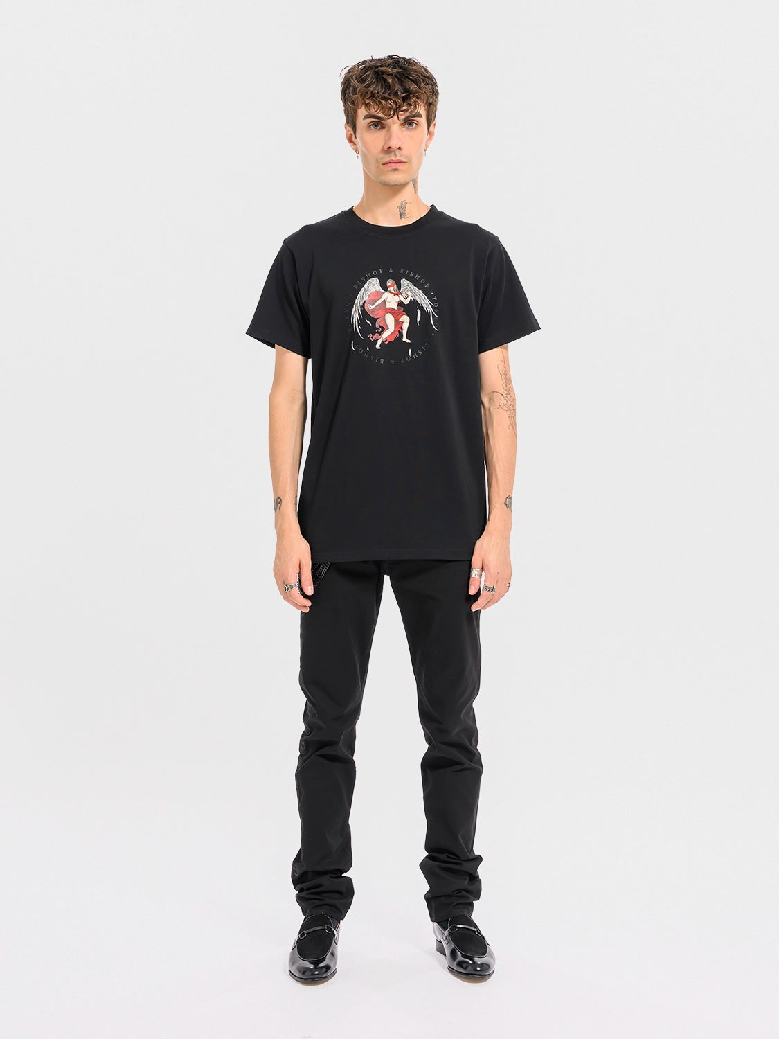 Man wearing a black T-shirt featuring an angel with wings and a red blindfold graphic on a white background.
