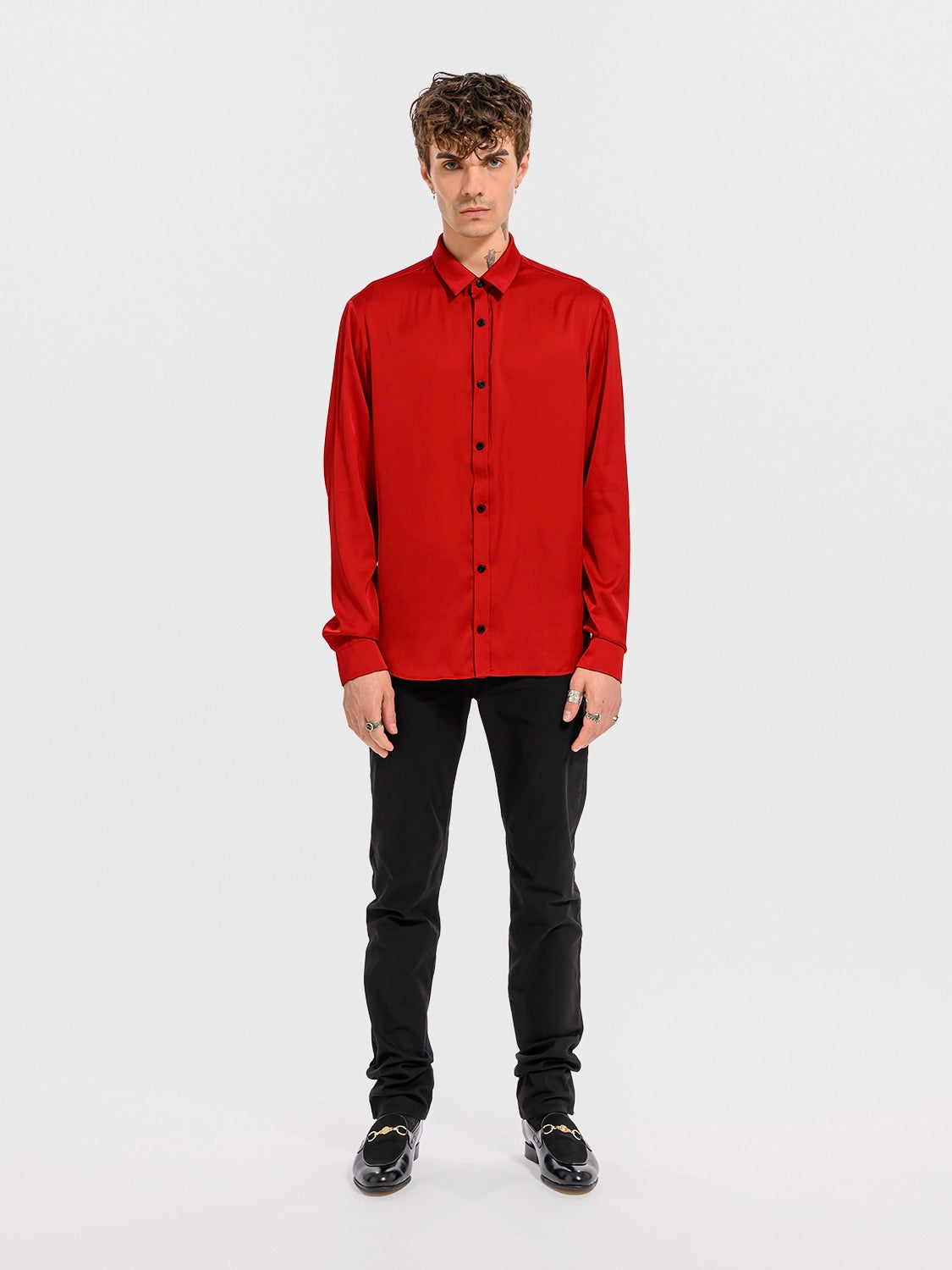 Man wearing a red shirt and black pants on a white background