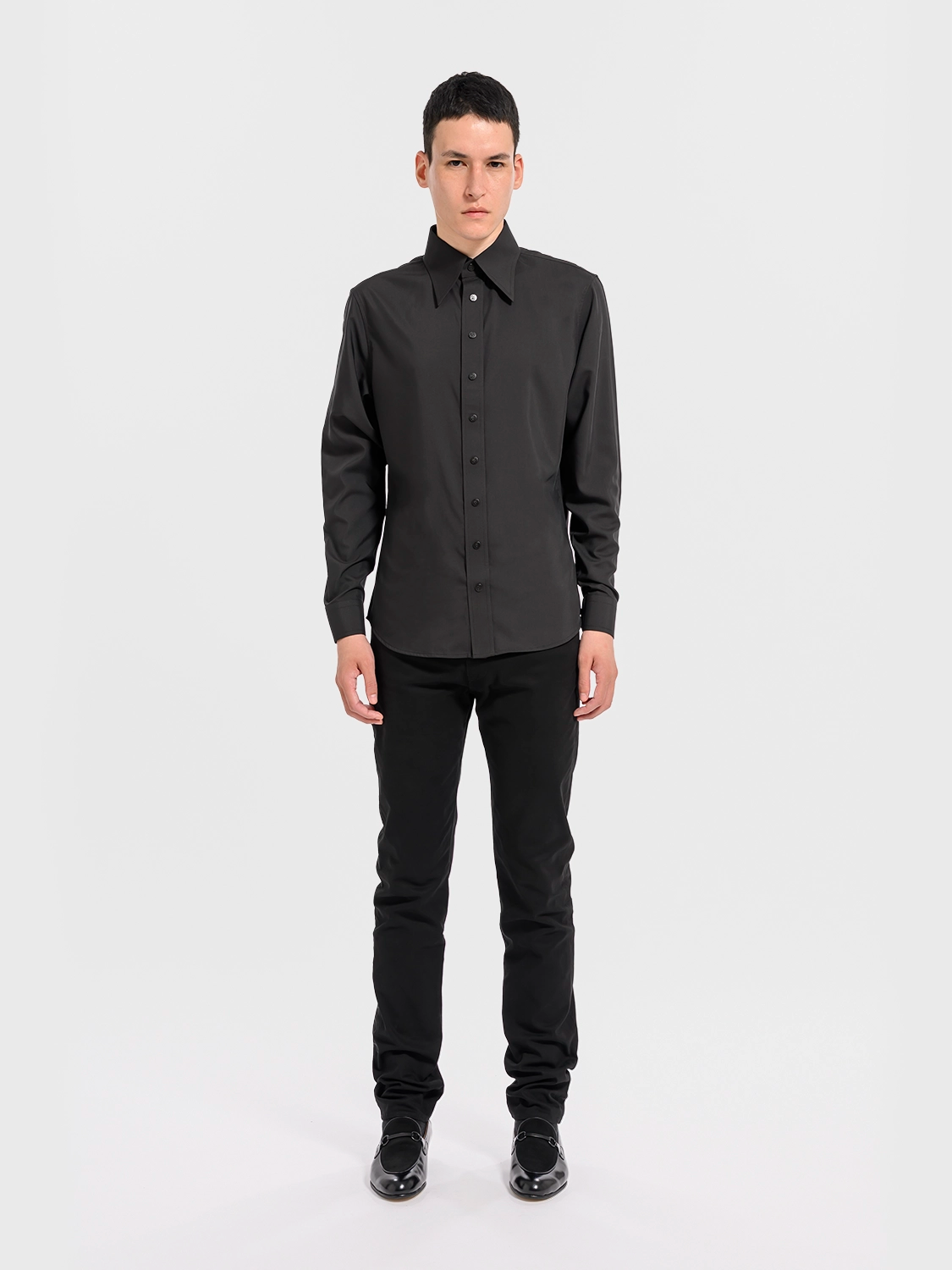 Person wearing a black shirt and pants on a white background