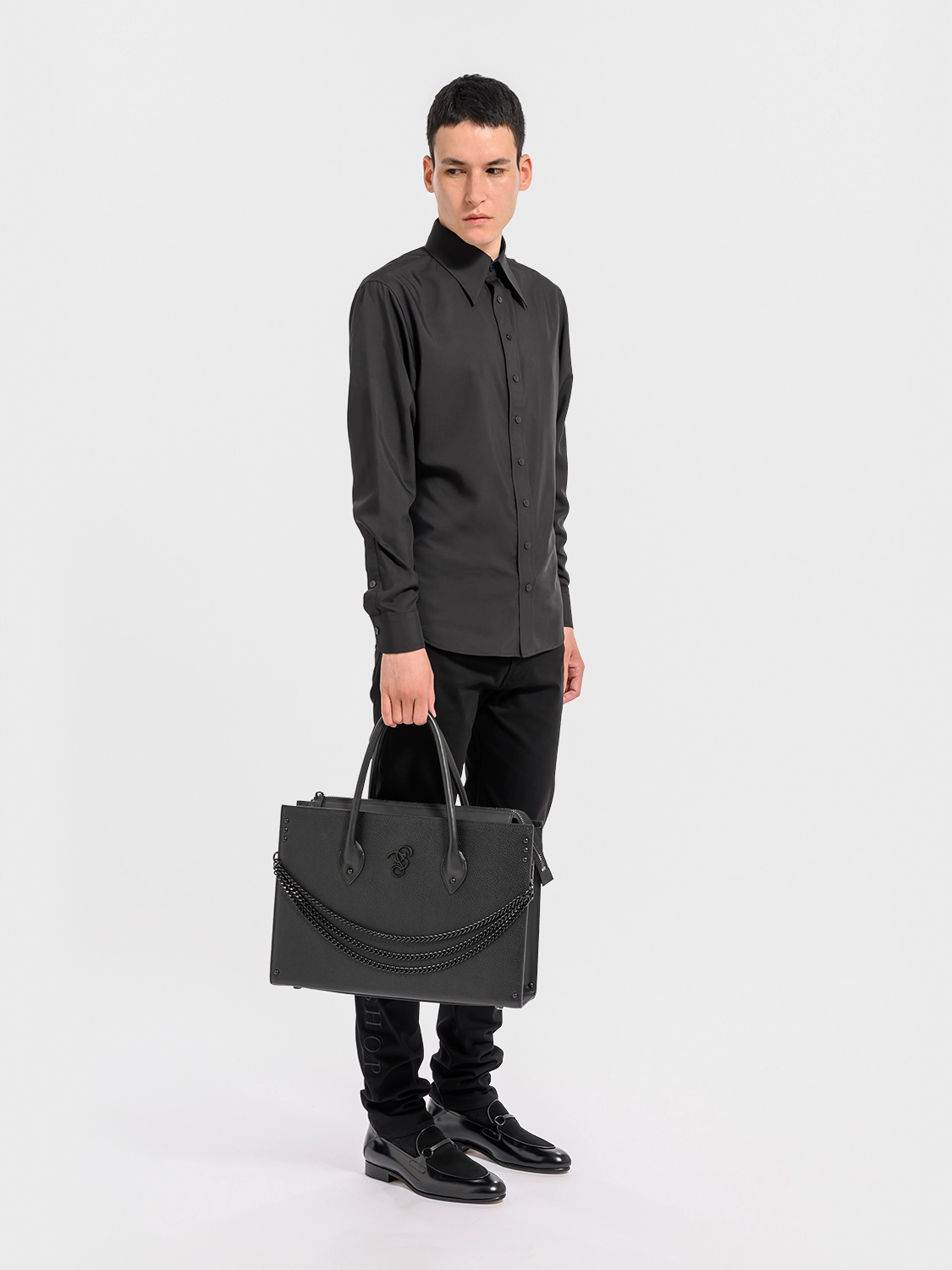 Man holding a black leather briefcase against a white background
