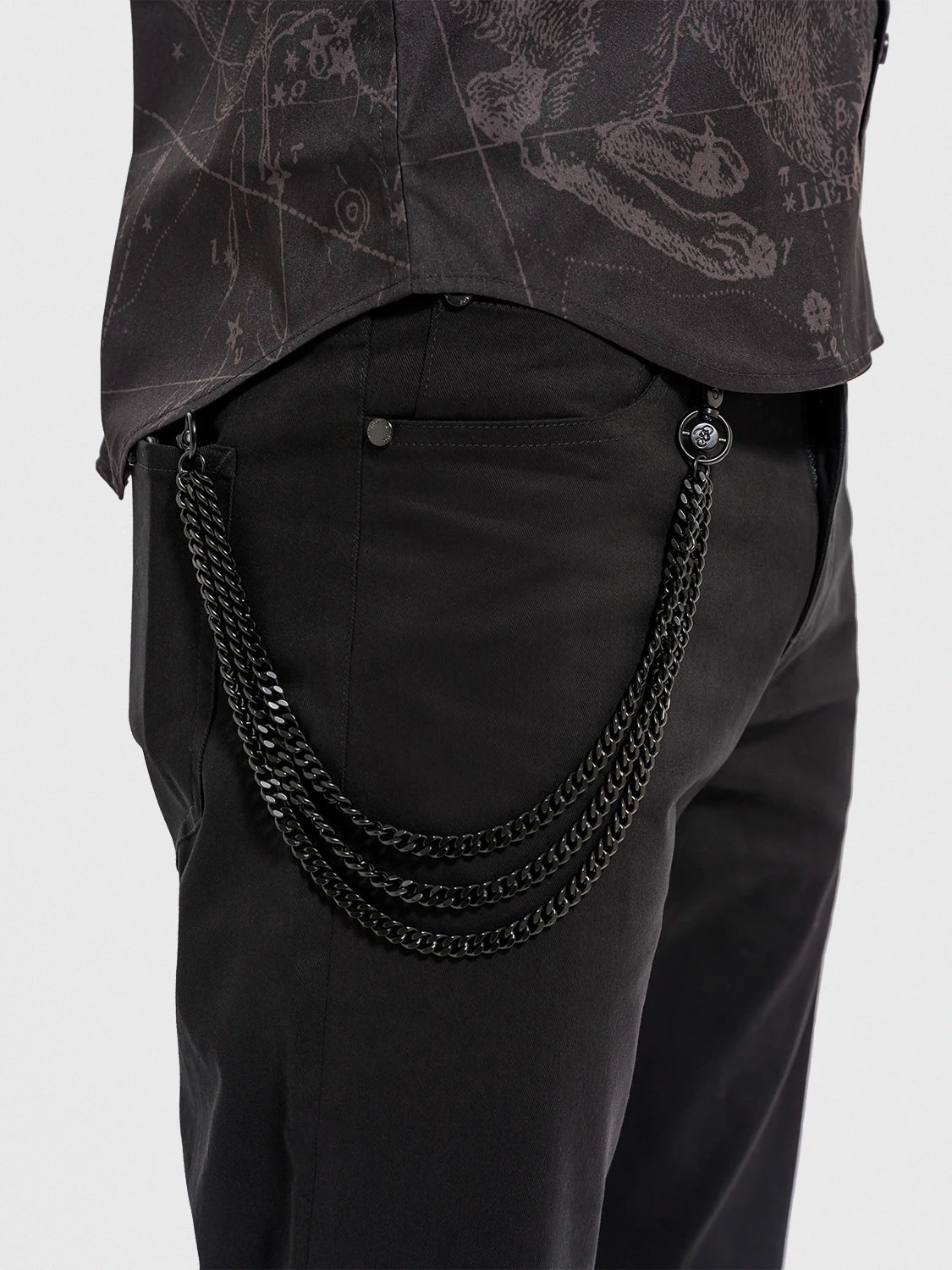 Black pants with a chain detail on a plain background